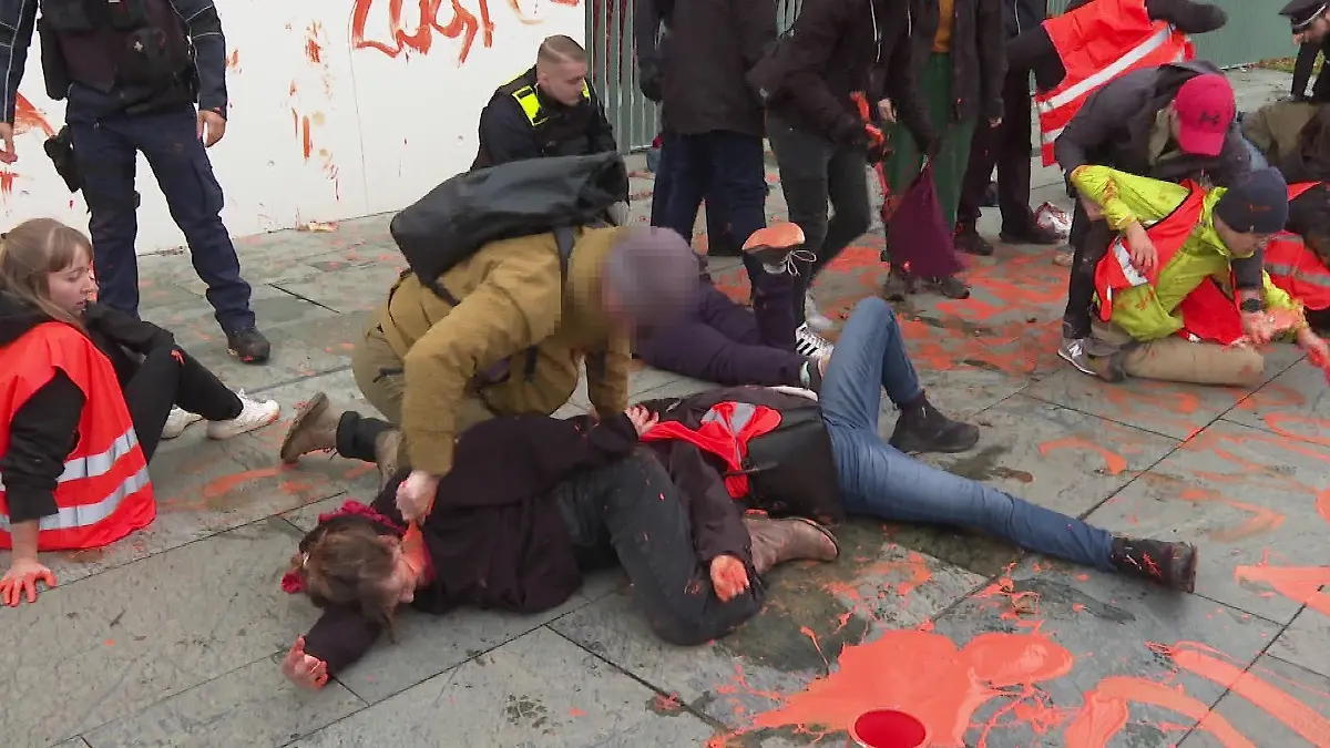 Brutalo-Aktion gegen Klimakleber: Ein angeblicher Zivil-Polizist bemalt das Gesicht einer Aktivistin.