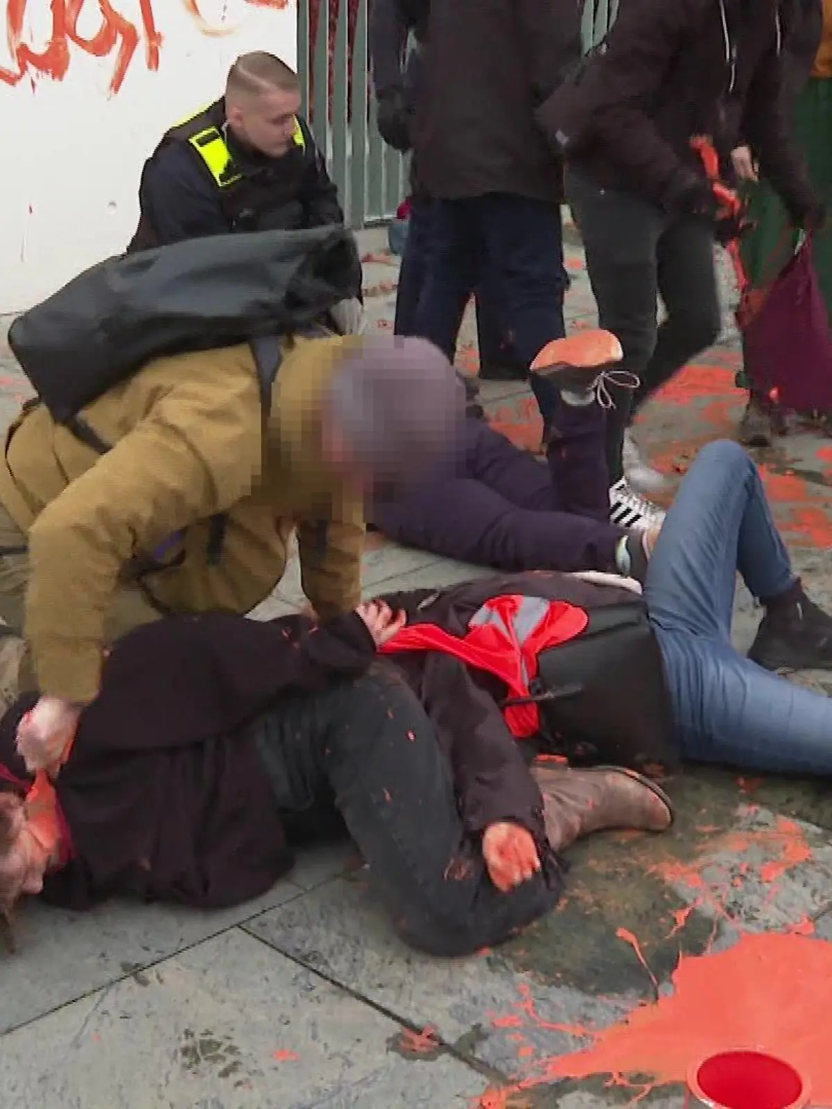 Brutalo-Aktion gegen Klimakleber: Ein angeblicher Zivil-Polizist bemalt das Gesicht einer Aktivistin.