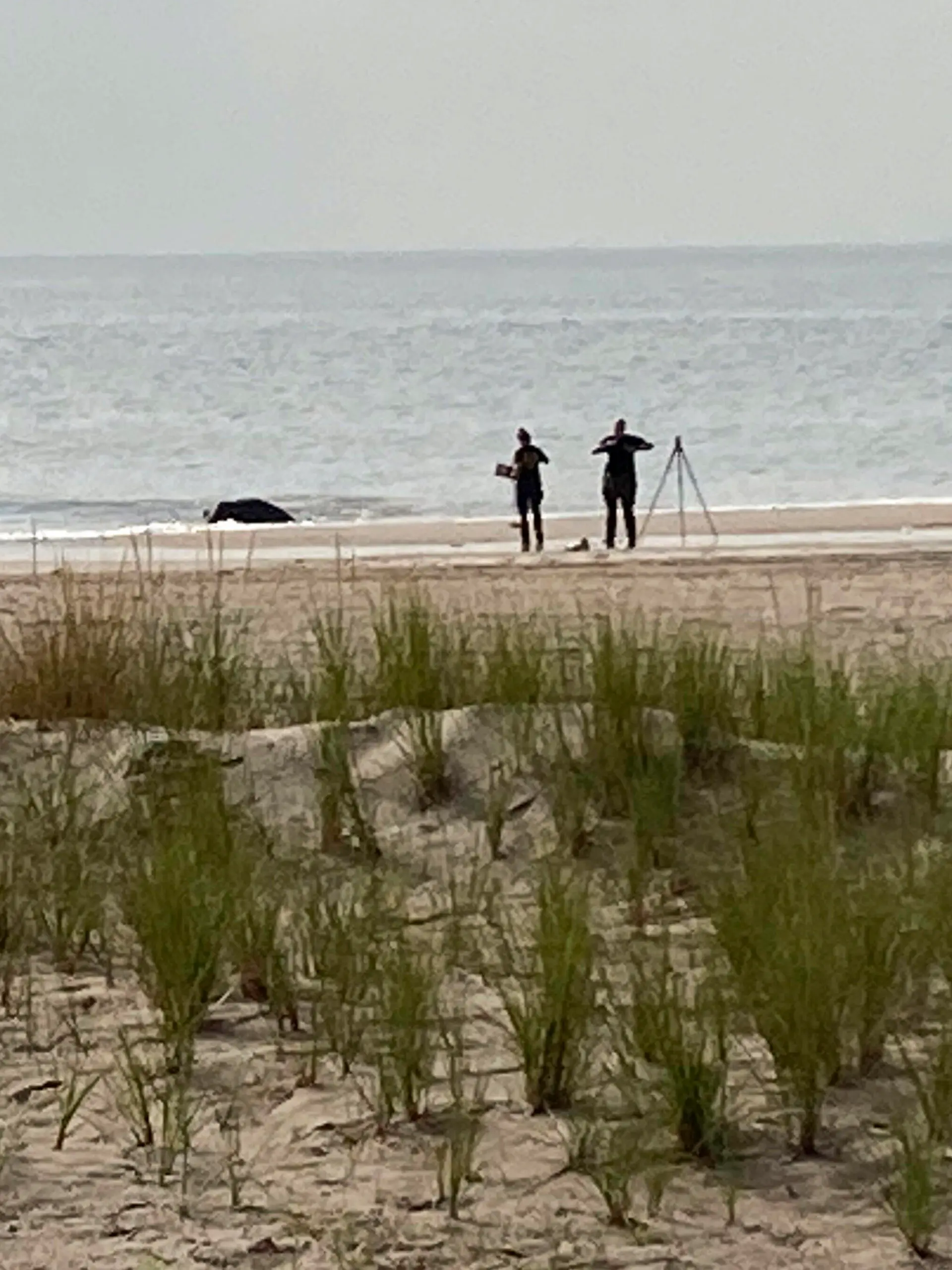New York Police investigators examine a stretch of beach at Coney Island where three children were found dead in the surf, Monday, Sept. 12, 2022, in New York. Authorities believe the children may have been drowned by their mother. (AP Photo/Joseph Frederick)