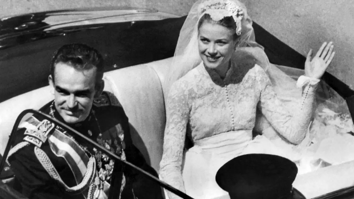 Nach ihrer Hochzeit in Monaco lächeln am 19. April 1956 Fürst Rainier III. und seine Braut, die Filmschauspielerin Grace Kelly, den Schaulustigen zu. Die am 12. November 1929 in Philadelphia geborene Grace Kelly, die spätere Fürstin Gracia Patricia von Monaco, hätte in diesem Jahr ihren 70. Geburtstag feiern können. Mit Filmen wie "Das Fenster zum Hof" und "Über den Dächern von Nizza" spielte sich der Hollywood-Star in den 50er Jahren in die Herzen der Zuschauer. Nach ihrer Hochzeit mit dem monegassischen Fürsten beendete sie jedoch ihre Filmkarriere und repräsentierte seitdem bis zu ihrem Unfalltod am 14.09.1982 das Fürstentum Monaco. dpa (zu dpa-Korr "First Lady des Films und des Fürsten - Grace Kelly wäre 70 geworden" vom 09.11.1999) nur s/w