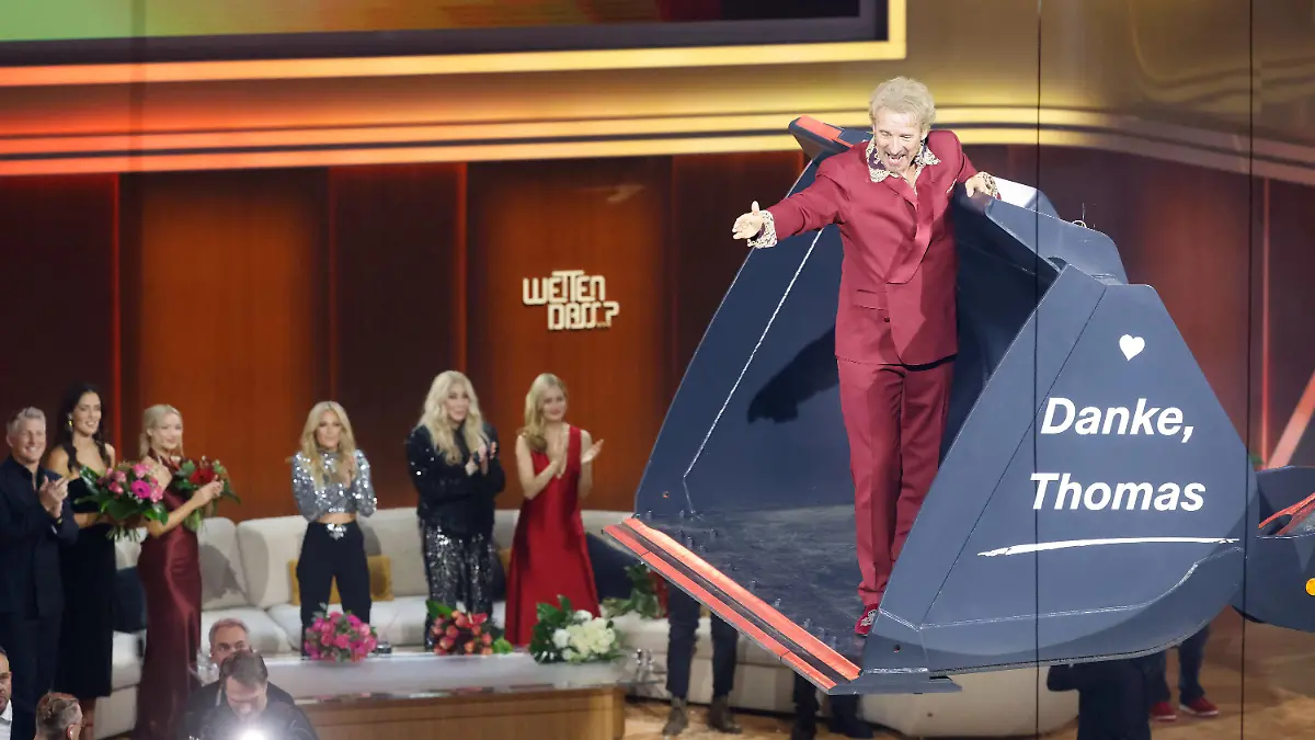 26.11.2023, Baden-Württemberg, Offenburg: Moderator Thomas Gottschalk wird am Ende der ZDF-Show "Wetten, dass..?" in einer Baggerschaufel über die Bühne gefahren. Gottschalk moderiert zum letzten Mal «Wetten, dass..?». Nach 36 Jahren beendet er am 25. November seine Karriere als Wett-Moderator. Foto: Philipp von Ditfurth/dpa +++ dpa-Bildfunk +++