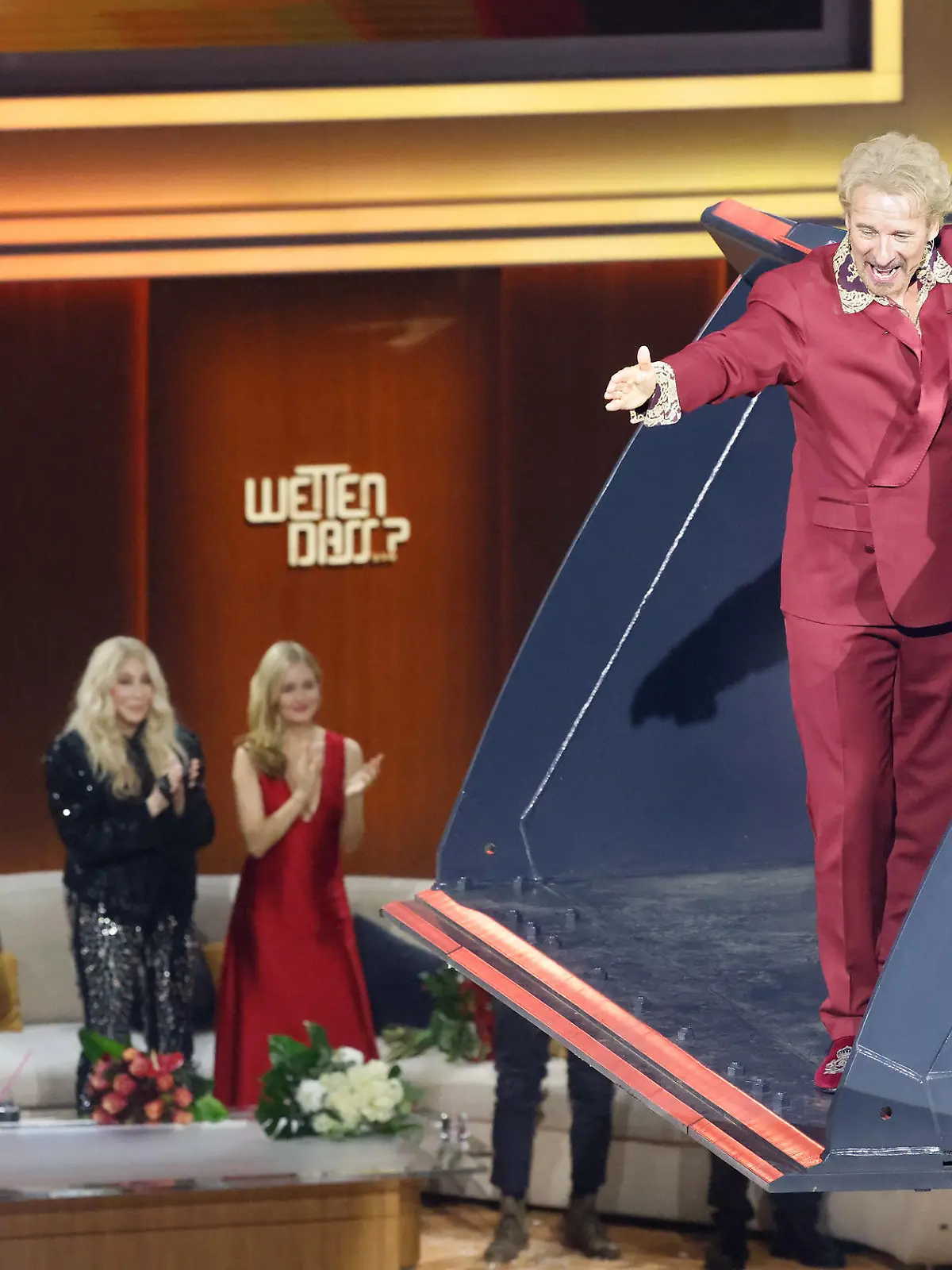 26.11.2023, Baden-Württemberg, Offenburg: Moderator Thomas Gottschalk wird am Ende der ZDF-Show "Wetten, dass..?" in einer Baggerschaufel über die Bühne gefahren. Gottschalk moderiert zum letzten Mal «Wetten, dass..?». Nach 36 Jahren beendet er am 25. November seine Karriere als Wett-Moderator. Foto: Philipp von Ditfurth/dpa +++ dpa-Bildfunk +++