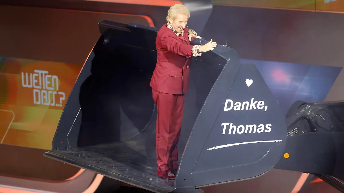 26.11.2023, Baden-Württemberg, Offenburg: Moderator Thomas Gottschalk wird am Ende der ZDF-Show "Wetten, dass..?" in einer Baggerschaufel über die Bühne gefahren. Gottschalk moderiert zum letzten Mal «Wetten, dass..?». Nach 36 Jahren beendet er am 25. November seine Karriere als Wett-Moderator. Foto: Philipp von Ditfurth/dpa +++ dpa-Bildfunk +++