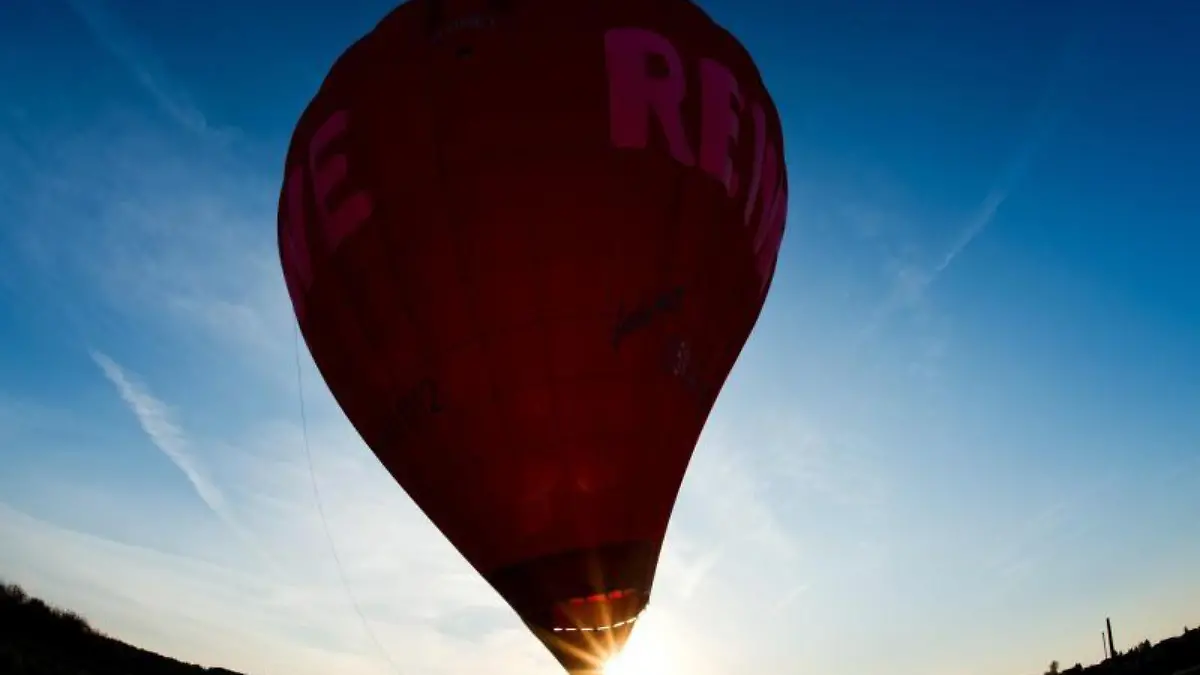 Ein Heißluftballon landet auf einem Feld