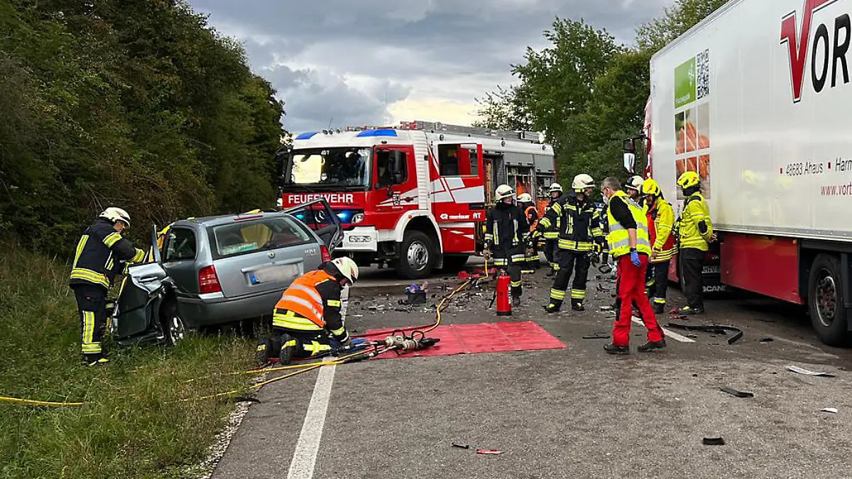 09.09.2022, Bayern, Weichering: Rettungskräfte arbeiten an einem Unfallort auf der B16. Bei einem Zusammenstoß ihres Autos mit einem Lkw ist eine Frau in Oberbayern tödlich verunglückt. Ihre beiden Söhne im Alter von fünf und neun Jahren wurden bei dem Unfall am Freitagnachmittag im Landkreis Neuburg-Schrobenhausen schwer verletzt, wie die Polizei am Abend mitteilte. Foto: Schmelzer/vifogra/dpa - ACHTUNG: Ein Kennzeichen wurde aus rechtlichen Gründen gepixelt +++ dpa-Bildfunk +++