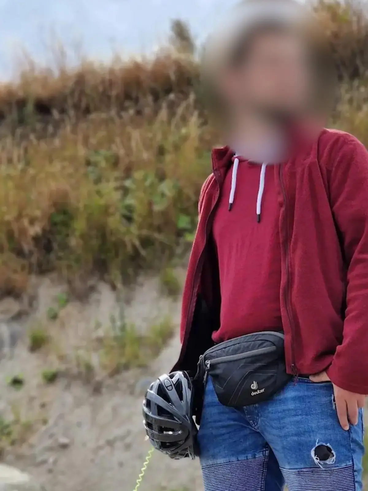 Ein Mann steht an einem Strand vor einer Düne.