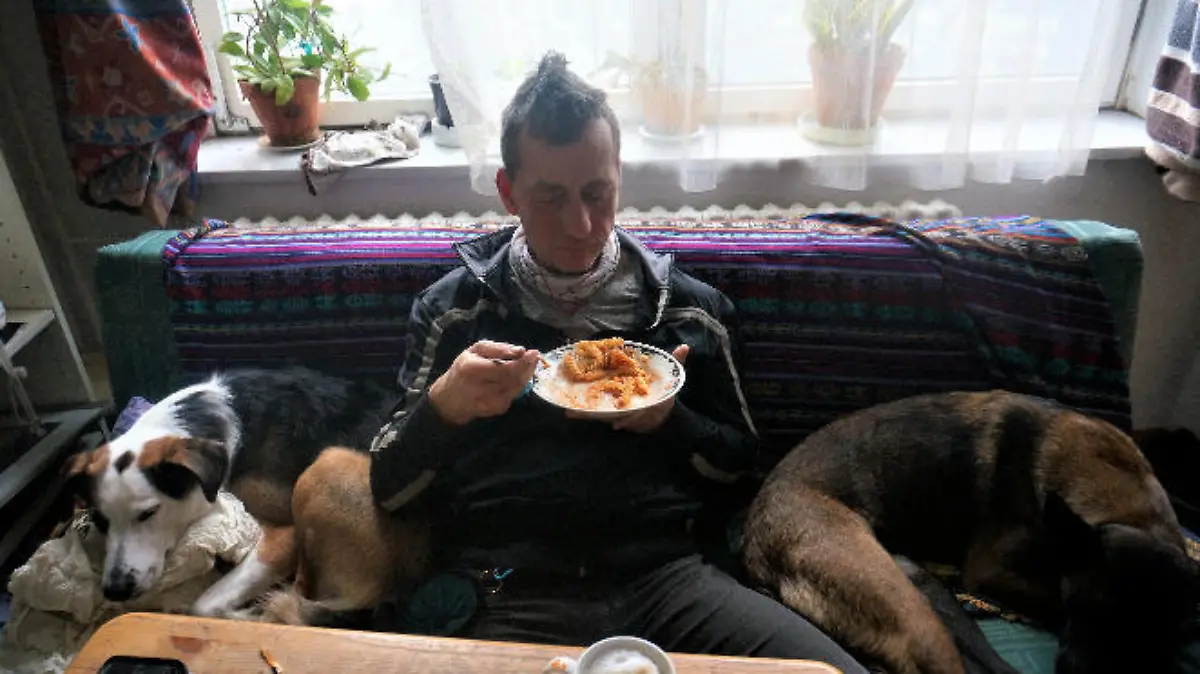 HANDOUT - 02.03.2024, ---, --: Das aktuelle Foto zeigt nach Angaben des Landeskriminalamtes Niedersachsen mit sehr hoher Wahrscheinlichkeit Burkhard Garweg zwischen zwei Hunden auf dem Sofa sitzend und essend. Mit einer Reihe aktueller Fotos wenden sich die Ermittlungsbehörden an die Bevölkerung, die Staatsanwaltschaft Verden und das Landeskriminalamt (LKA) Niedersachsen bitten um Hinweise. 
Die Ermittlungsbehörden fahnden weiterhin öffentlich nach den beiden noch flüchtigen mutmaßlichen Räubern Ernst-Volker Staub und Burkhard Garweg. Aufgenommen wurden die Bilder in den Jahren von 2021 bis 2024. Foto: ---/Landeskriminalamt Niedersachsen/dpa - ACHTUNG: Nur zur redaktionellen Verwendung im Zusammenhang mit der aktuellen Berichterstattung und nur mit vollständiger Nennung des vorstehenden Credits +++ dpa-Bildfunk +++