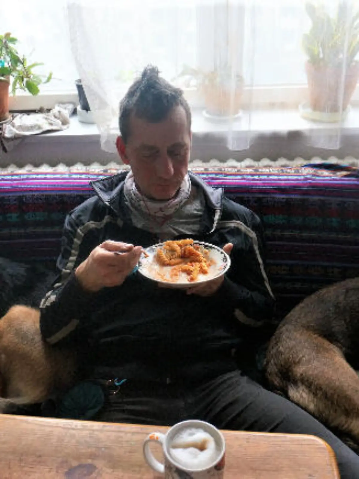 HANDOUT - 02.03.2024, ---, --: Das aktuelle Foto zeigt nach Angaben des Landeskriminalamtes Niedersachsen mit sehr hoher Wahrscheinlichkeit Burkhard Garweg zwischen zwei Hunden auf dem Sofa sitzend und essend. Mit einer Reihe aktueller Fotos wenden sich die Ermittlungsbehörden an die Bevölkerung, die Staatsanwaltschaft Verden und das Landeskriminalamt (LKA) Niedersachsen bitten um Hinweise. 
Die Ermittlungsbehörden fahnden weiterhin öffentlich nach den beiden noch flüchtigen mutmaßlichen Räubern Ernst-Volker Staub und Burkhard Garweg. Aufgenommen wurden die Bilder in den Jahren von 2021 bis 2024. Foto: ---/Landeskriminalamt Niedersachsen/dpa - ACHTUNG: Nur zur redaktionellen Verwendung im Zusammenhang mit der aktuellen Berichterstattung und nur mit vollständiger Nennung des vorstehenden Credits +++ dpa-Bildfunk +++