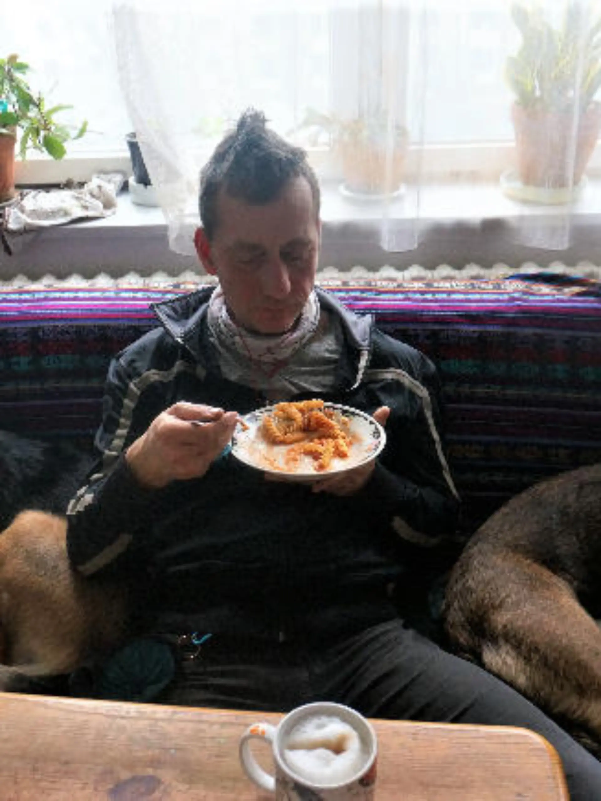 HANDOUT - 02.03.2024, ---, --: Das aktuelle Foto zeigt nach Angaben des Landeskriminalamtes Niedersachsen mit sehr hoher Wahrscheinlichkeit Burkhard Garweg zwischen zwei Hunden auf dem Sofa sitzend und essend. Mit einer Reihe aktueller Fotos wenden sich die Ermittlungsbehörden an die Bevölkerung, die Staatsanwaltschaft Verden und das Landeskriminalamt (LKA) Niedersachsen bitten um Hinweise. 
Die Ermittlungsbehörden fahnden weiterhin öffentlich nach den beiden noch flüchtigen mutmaßlichen Räubern Ernst-Volker Staub und Burkhard Garweg. Aufgenommen wurden die Bilder in den Jahren von 2021 bis 2024. Foto: ---/Landeskriminalamt Niedersachsen/dpa - ACHTUNG: Nur zur redaktionellen Verwendung im Zusammenhang mit der aktuellen Berichterstattung und nur mit vollständiger Nennung des vorstehenden Credits +++ dpa-Bildfunk +++