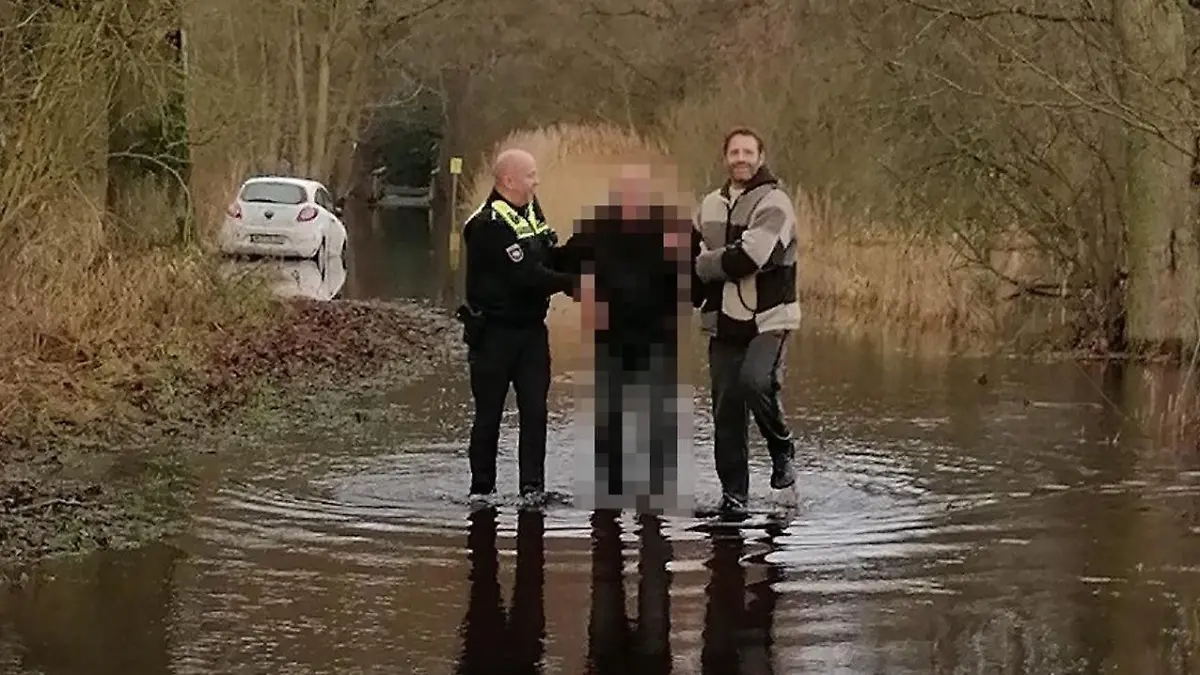 Mit vereinten Kräften befreien der Beamte und der Radfahrer den Senior.