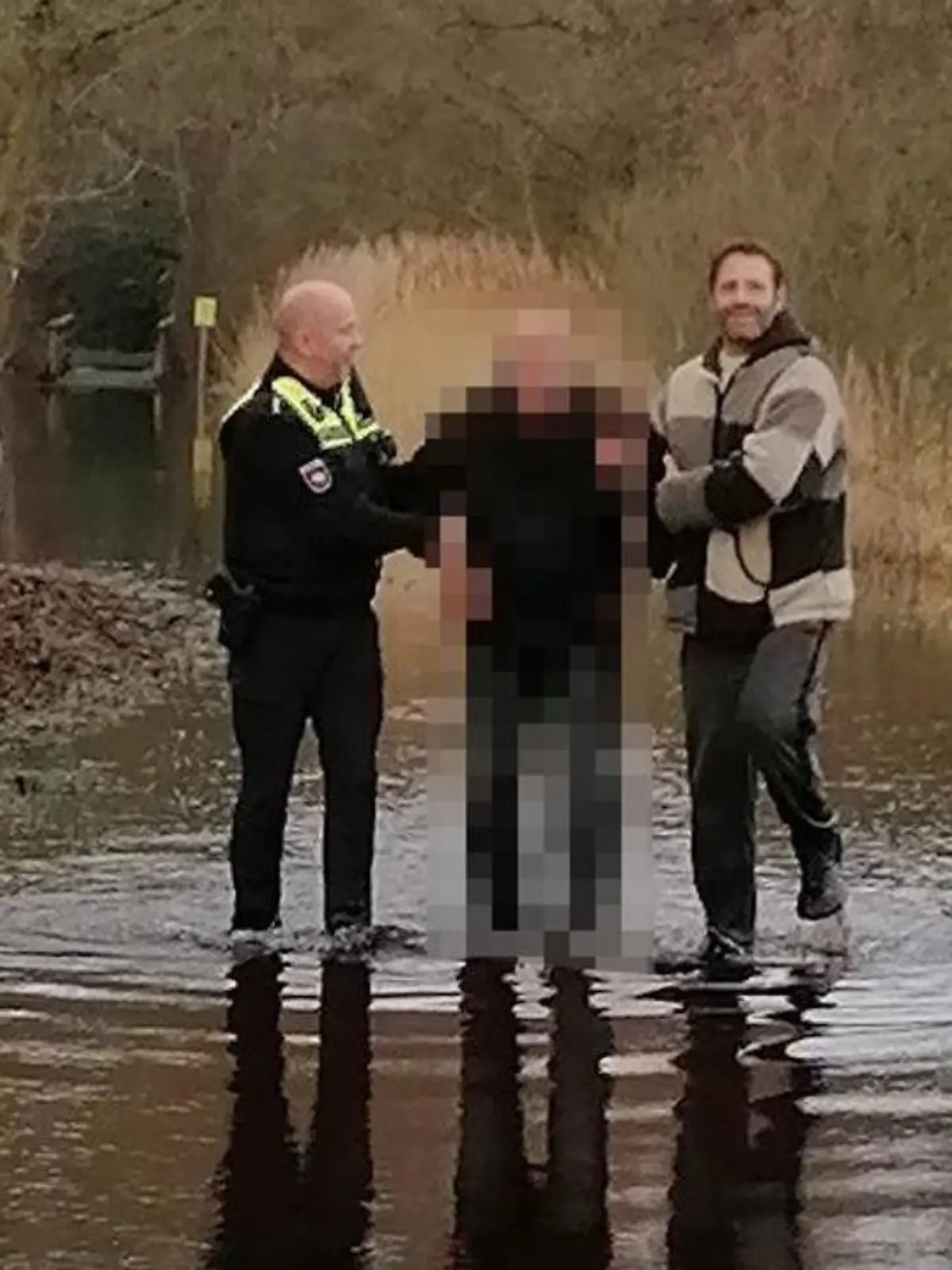 Mit vereinten Kräften befreien der Beamte und der Radfahrer den Senior.