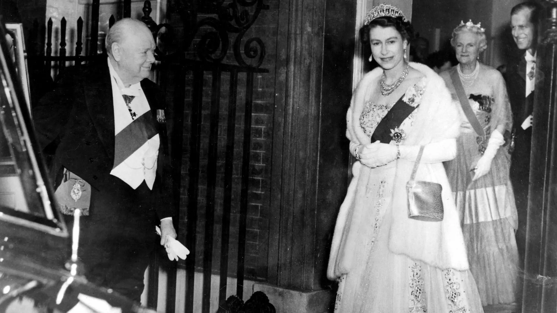 HM The Queen and HRH the Duke of Edinburgh were guests at a dinner party given by Sir Winston Churchill at No 10 Downing Street this evening. Among the other guests were very old and recent friends of the Prime Minister. It is greatly rumoured in London that the resignation of the Prime Minister is imminent. Photo shows Sir Winston Churchill holding the door of the royal car, when HM Queen Elizabeth and the Duke of Edinburgh leave No 10 Downing Street after the dinner party this evening. Lady Churchill can be seen in the entrance of No 10 - 4th April 1955 UnitedArchives00373603 PUBLICATIONxINxGERxSUIxAUTxONLY