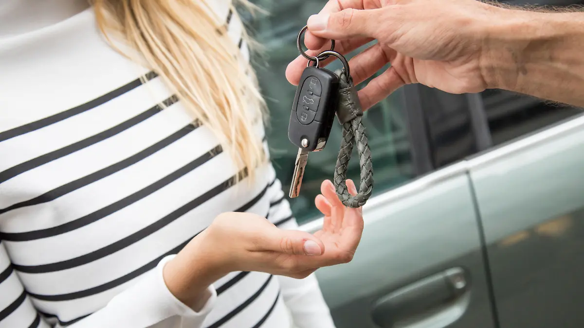 Mann übergibt Frau einen Autoschlüssel