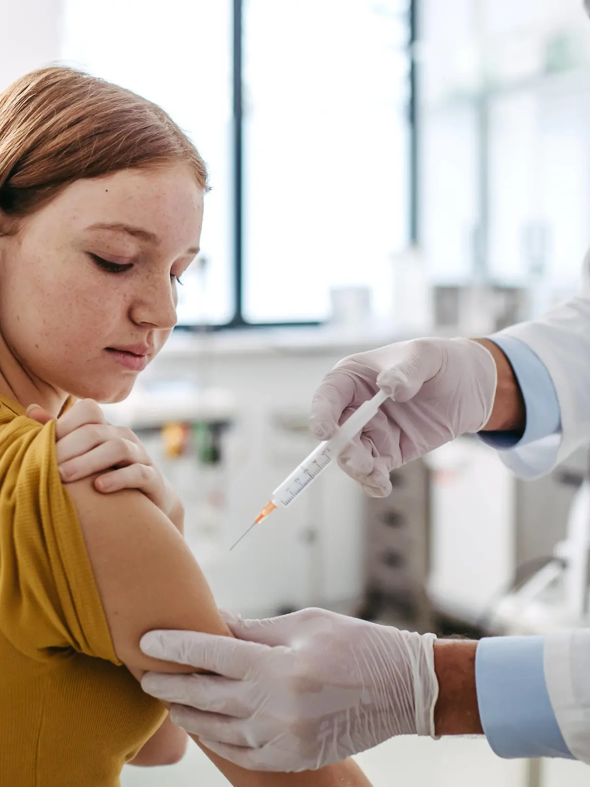 Doctor, pediatrician injecting vaccine into teenage girl arm. Concept of preventive health care and vaccination for teenagers. Doctor, pediatrician injecting vaccine into teenage girl arm. Concept of preventive health care and vaccination for teenagers, immunisation. model released