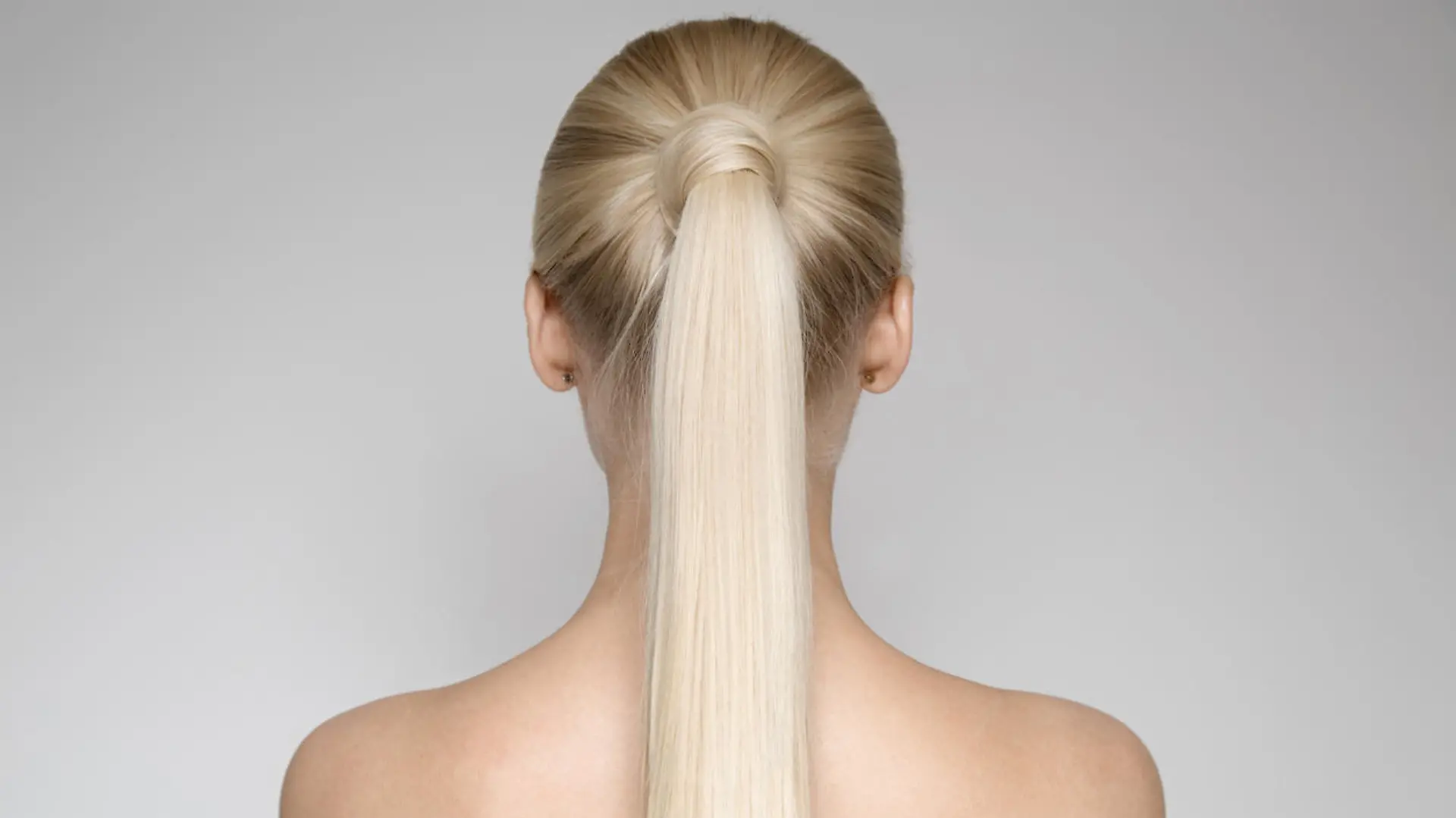 Portrait Of A Beautiful Young Blond Woman With Ponytail Hairstyle. Back view