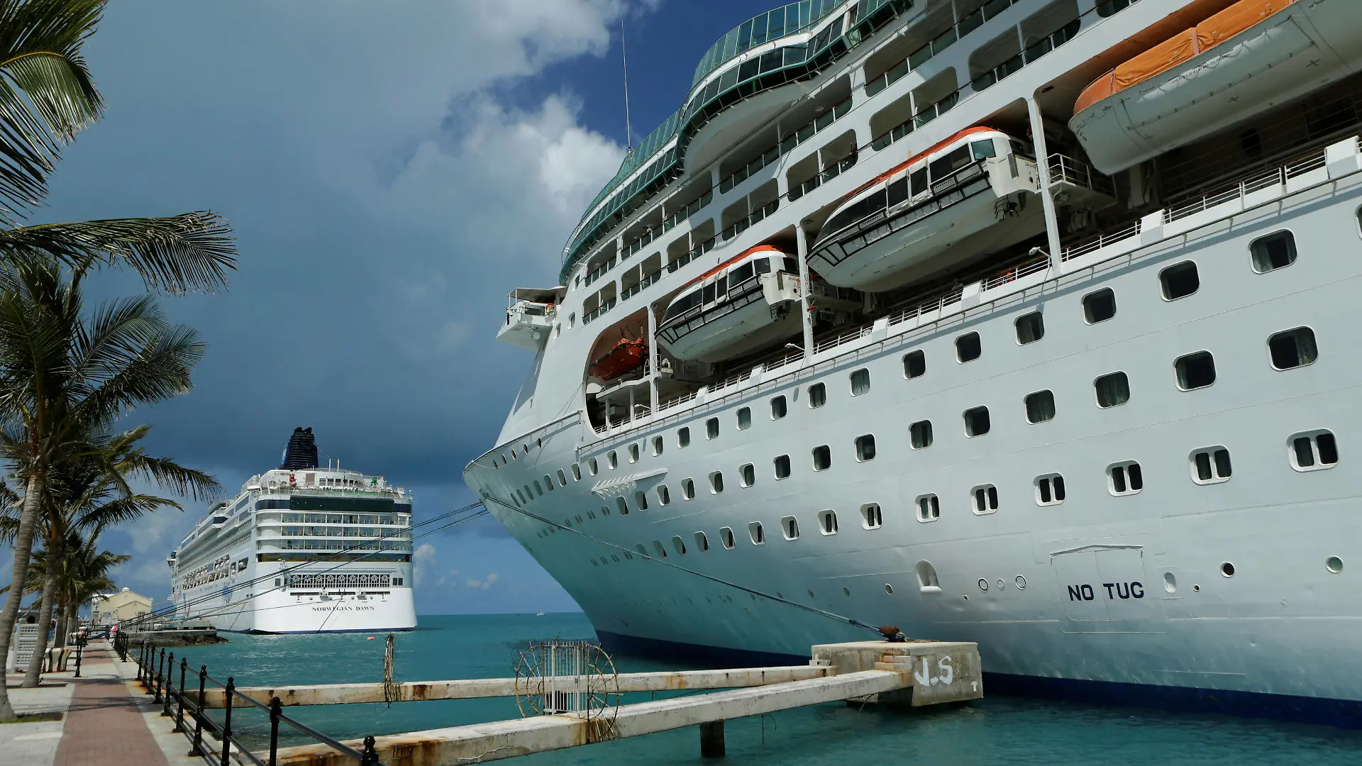 FILE PHOTO: Cruise ships of the Norwegian Cruise Line 'Norwegian Dawn" (L) and Royal Caribbean's 'Grandeur of the Seas" (R) are seen docked at the Royal Naval Dockyard near the port of Hamilton, Bermuda. REUTERS/Gary Cameron (BERMUDA)/File Photo