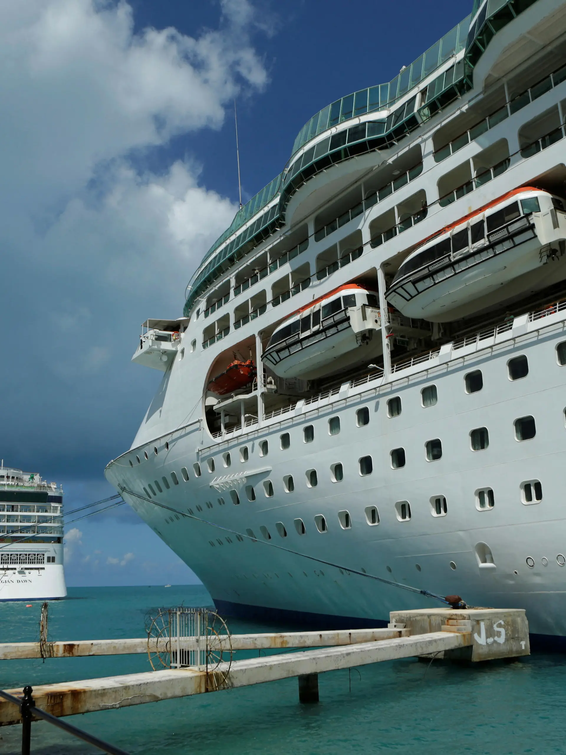 FILE PHOTO: Cruise ships of the Norwegian Cruise Line 'Norwegian Dawn" (L) and Royal Caribbean's 'Grandeur of the Seas" (R) are seen docked at the Royal Naval Dockyard near the port of Hamilton, Bermuda. REUTERS/Gary Cameron (BERMUDA)/File Photo