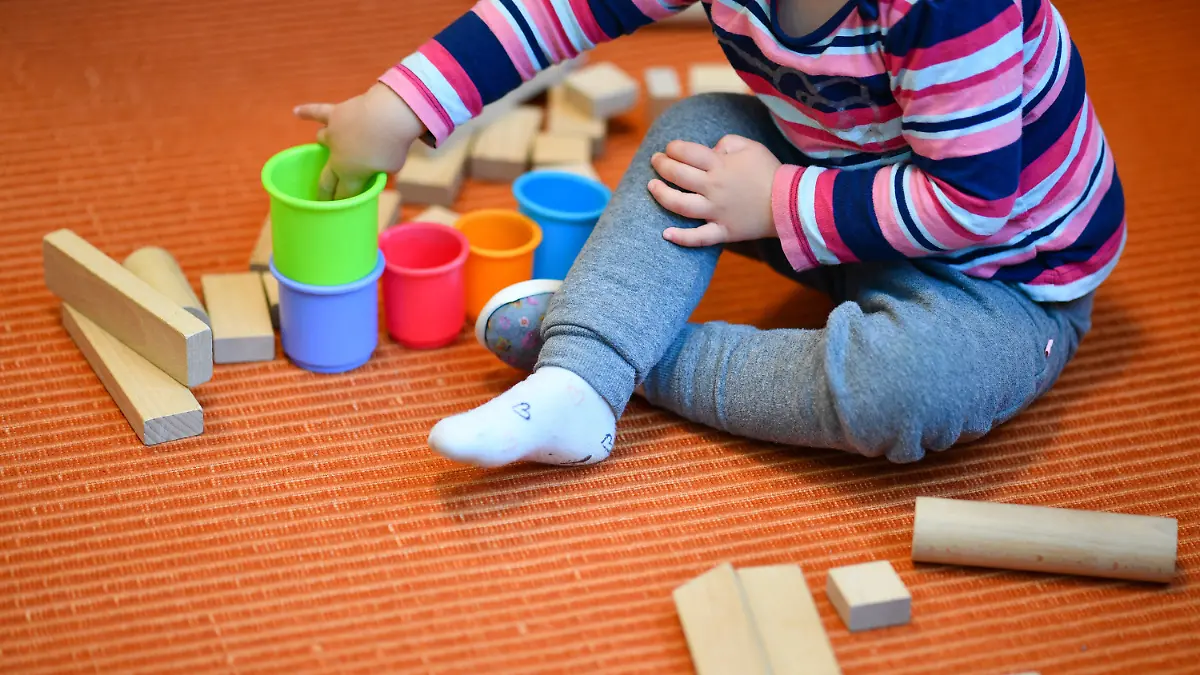 ARCHIV - 20.10.2017, Baden-Württemberg, Mannheim: Ein Mädchen spielt in einer Kita mit bunten Bechern und Bauklötzen. (zu dpa: «Immer mehr unter Dreijährige in Kita oder von Tageseltern betreut») Foto: Uwe Anspach/dpa +++ dpa-Bildfunk +++