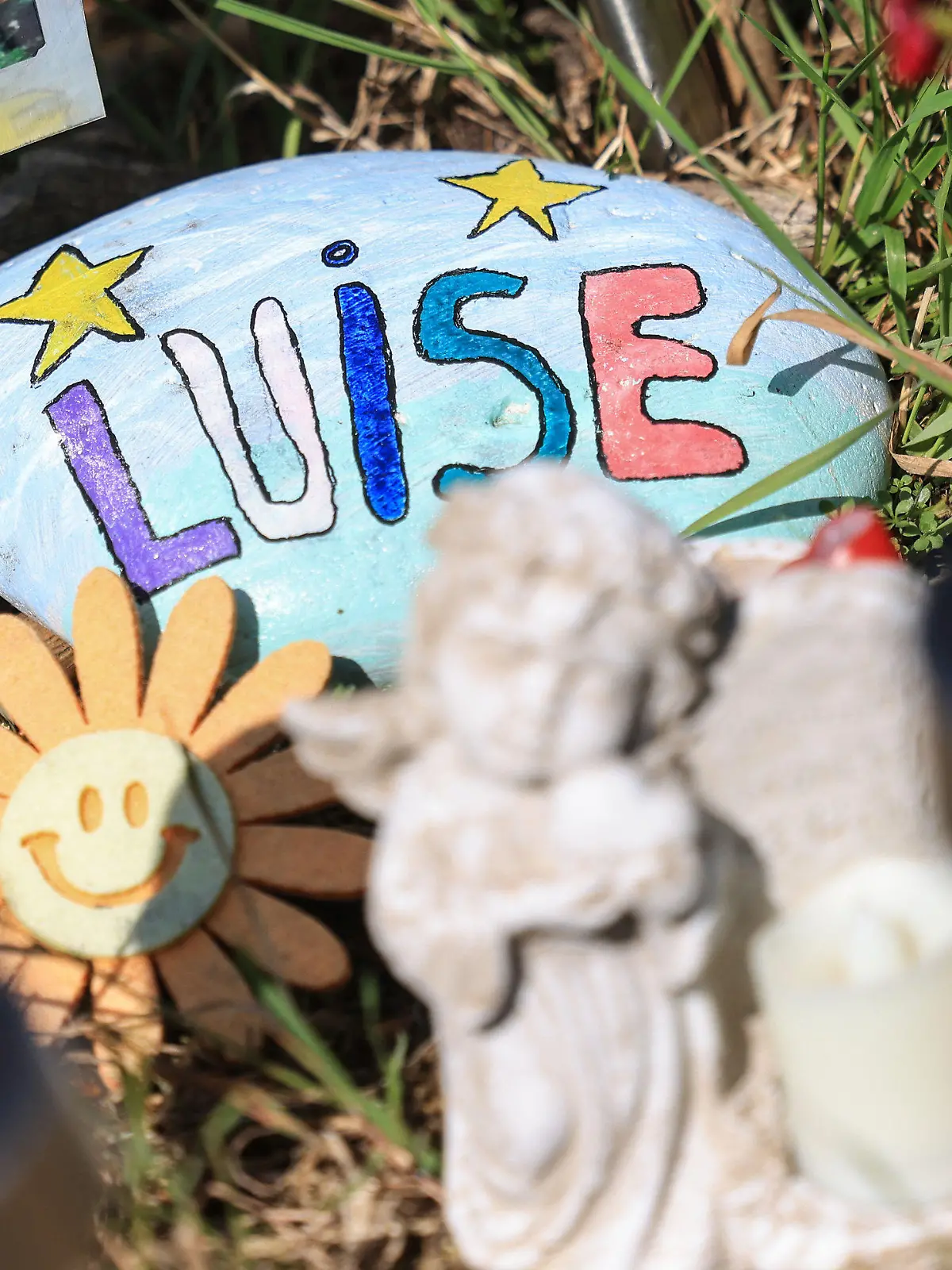 ARCHIV - 11.07.2023, Nordrhein-Westfalen, Freudenberg: Ein Stein mit dem aufgemaltem Namen "Luise" liegt am Waldrand an der Stelle, an der das Mädchen Luise tot gefunden wurde. Ein Jahr ist es her, dass die Zwölfjährige in dem Waldstück bei Freudenberg in Südwestfalen erstochen wurde. Zwei Mädchen, selbst erst 12 und 13 Jahre alt, haben die Tat gestanden. (zu dpa: «Ein Jahr nach gewaltsamen Tod von Luise: «Das Entsetzen bleibt»») Foto: Oliver Berg/dpa +++ dpa-Bildfunk +++