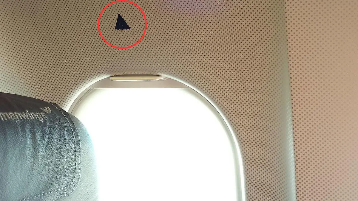 Was hat das kleine Dreieck über manchen Flugzeugfenstern zu bedeuten? Wir haben die Erklärung.