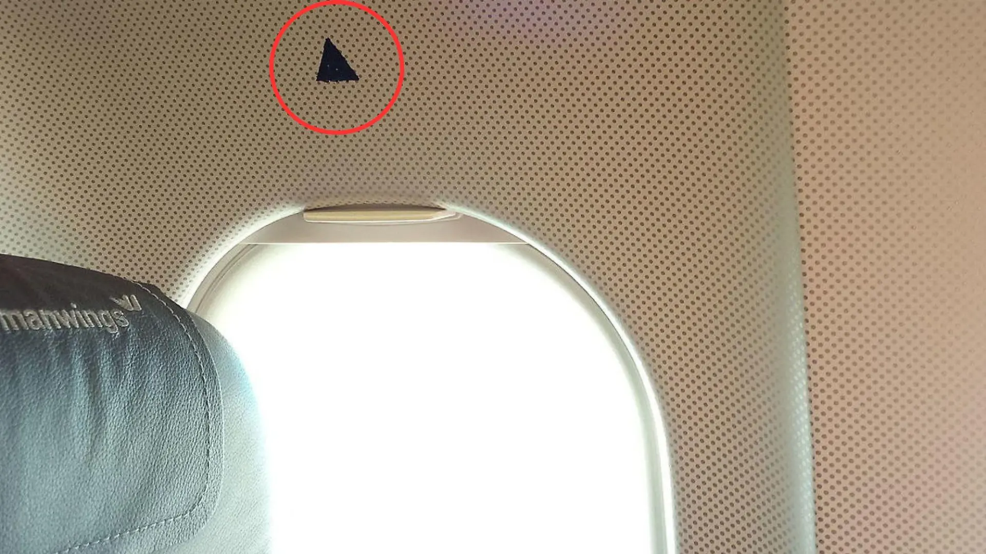Was hat das kleine Dreieck über manchen Flugzeugfenstern zu bedeuten? Wir haben die Erklärung.