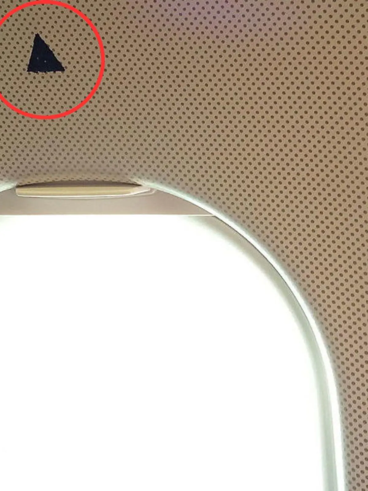 Was hat das kleine Dreieck über manchen Flugzeugfenstern zu bedeuten? Wir haben die Erklärung.