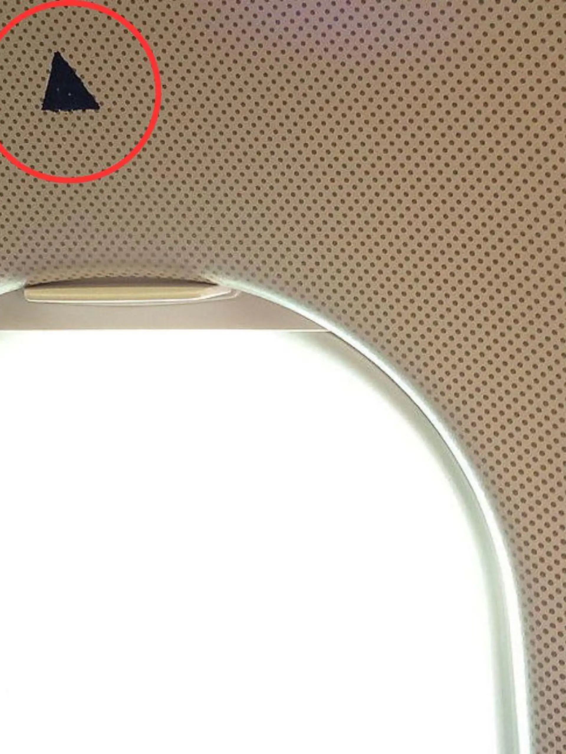 Was hat das kleine Dreieck über manchen Flugzeugfenstern zu bedeuten? Wir haben die Erklärung.