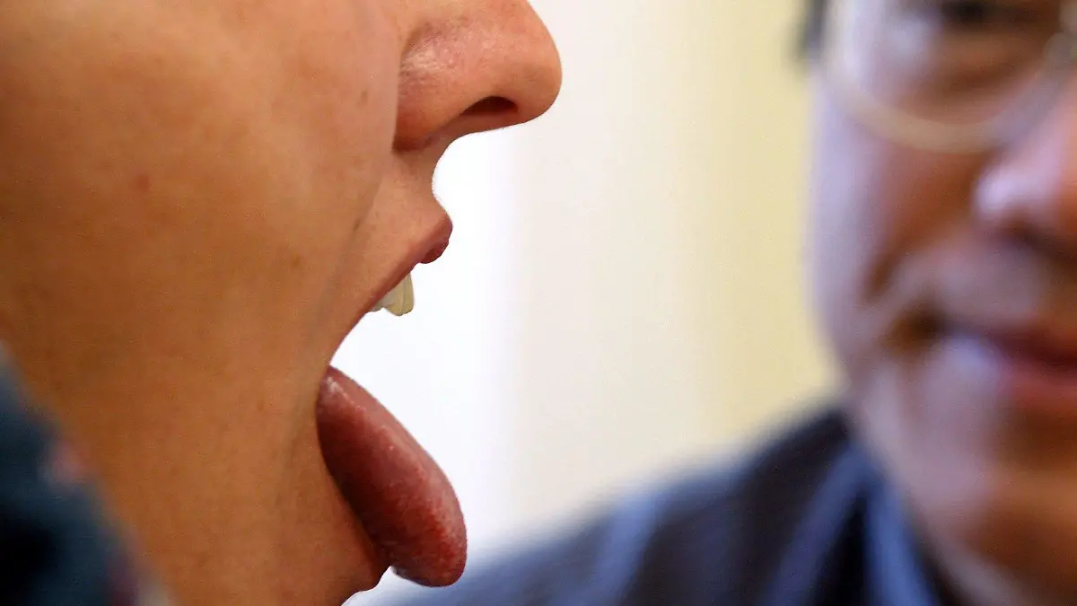 Ein chinesischer Arzt begutachtet am Mittwoch (23.06.2004) in der Klinik für Traditionelle Chinesische Medizin in Ottobeuren die Zunge einer Patientin. Die Zungendiagnose soll Aufschluß über den Gesundheitszustand der Frau geben. Foto: Karl-Josef Hildenbrand dpa/lby