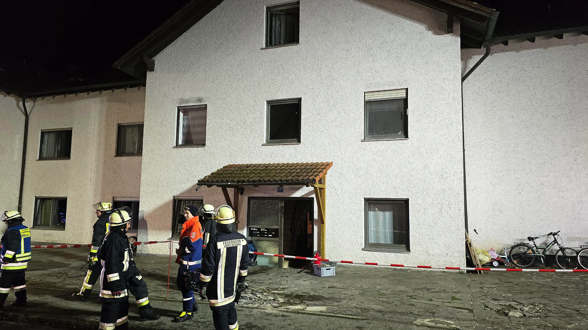 07.03.2024, Bayern, Nittenau: Einsatzkräfte der Feuerwehr stehen nach einem Brand vor einem Wohnkomplex in der Oberpfalz. Bei dem Brand in einem großen Wohnkomplex im Landkreis Schwandorf sind mehr als 30 Menschen durch Rauch verletzt worden, wie ein Sprecher der Feuerwehr mitteilte. Foto: Moller-Schuh/Vifogra/dpa +++ dpa-Bildfunk +++