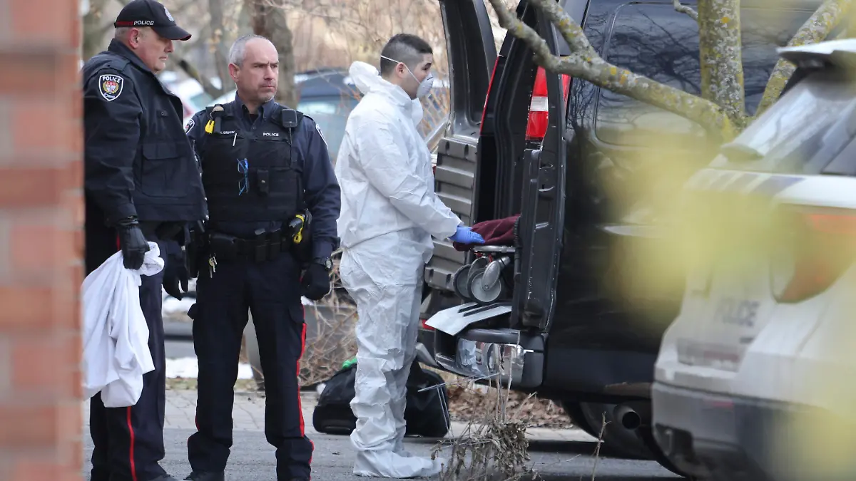 A member of the coroner's office moves a stretcher at the scene of a homicide where six people were found dead in the Barrhaven suburb of Ottawa on Thursday, March 7, 2024. (Patrick Doyle /The Canadian Press via AP)