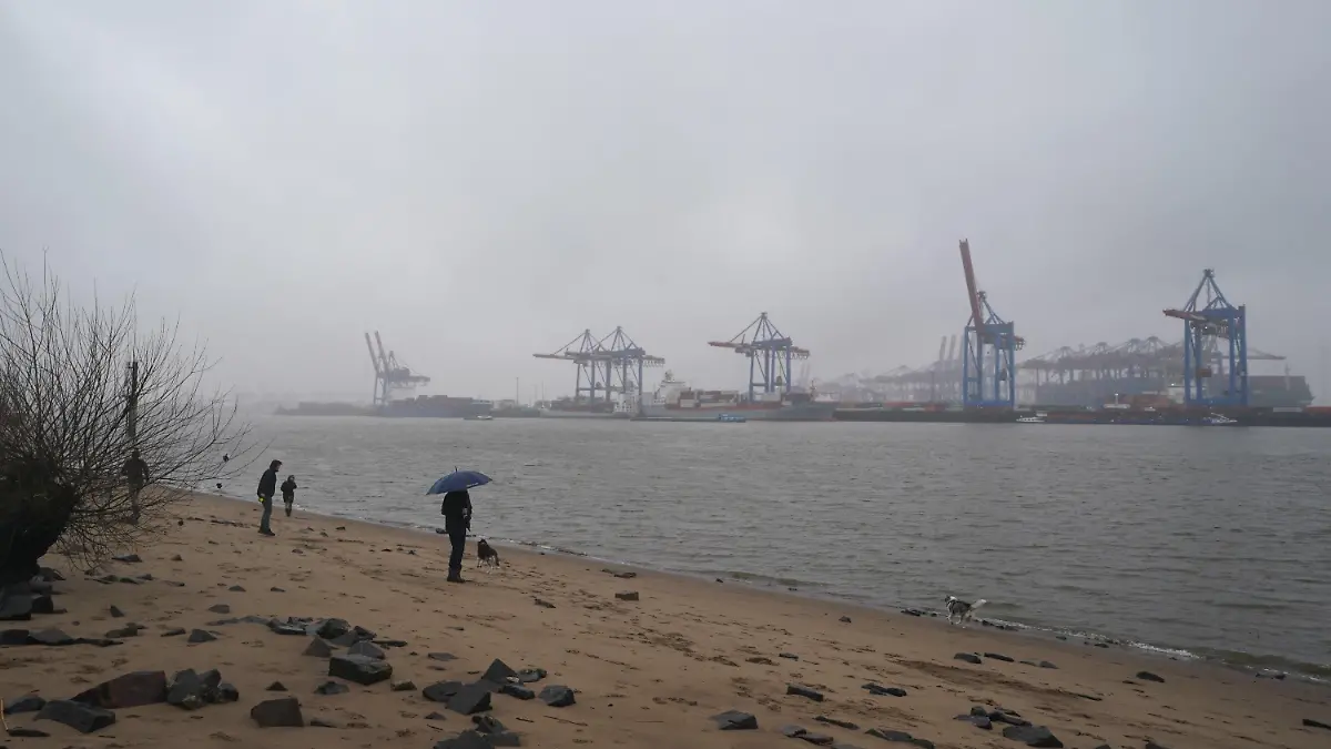 ARCHIV - 02.01.2024, Hamburg: Passanten gehen im strömenden Regen am Elbstrand in Ovelgönne spazieren. (zu dpa: «Ungemütlich und mild - DWD zieht Winter-Wetterbilanz für Hamburg») Foto: Marcus Brandt/dpa +++ dpa-Bildfunk +++