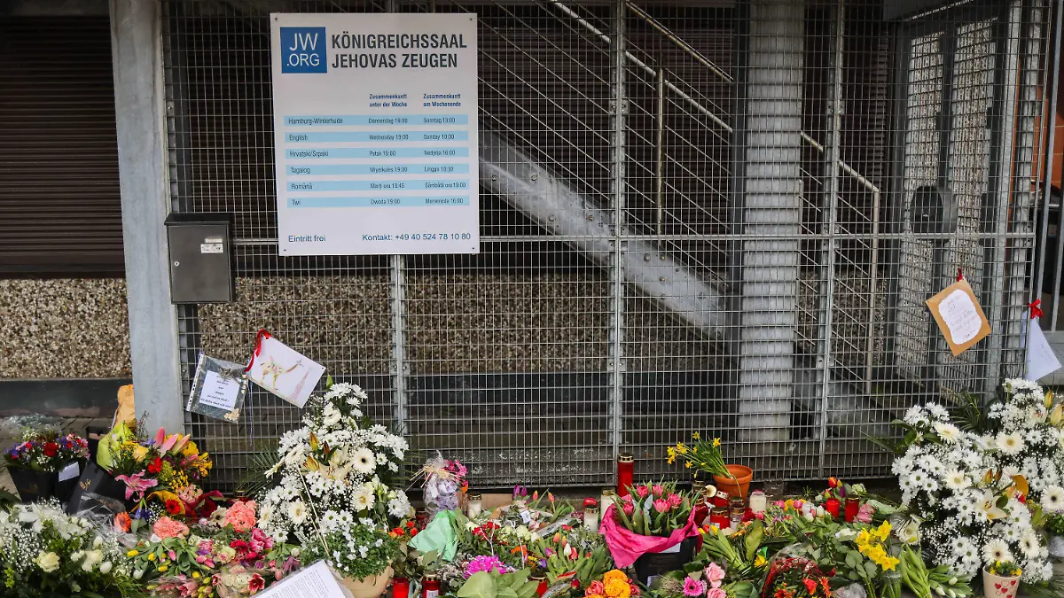 ARCHIV - 16.03.2023, Hamburg: Blumen und Kerzen sind vor dem Eingangsbereich eines Gemeindehauses der Zeugen Jehovas zu sehen. Bei einem Amoklauf während einer Veranstaltung der Zeugen Jehovas sind am 9. März 2023 acht Menschen getötet und weitere Personen verletzt worden. (zu dpa: «Ein Jahr nach Amoklauf · Zeugen Jehovas haben «mit Liebe reagiert»») (zu dpa: «Ein Jahr nach Amoklauf · Zeugen Jehovas haben «mit Liebe reagiert»») Foto: Christian Charisius/dpa +++ dpa-Bildfunk +++
