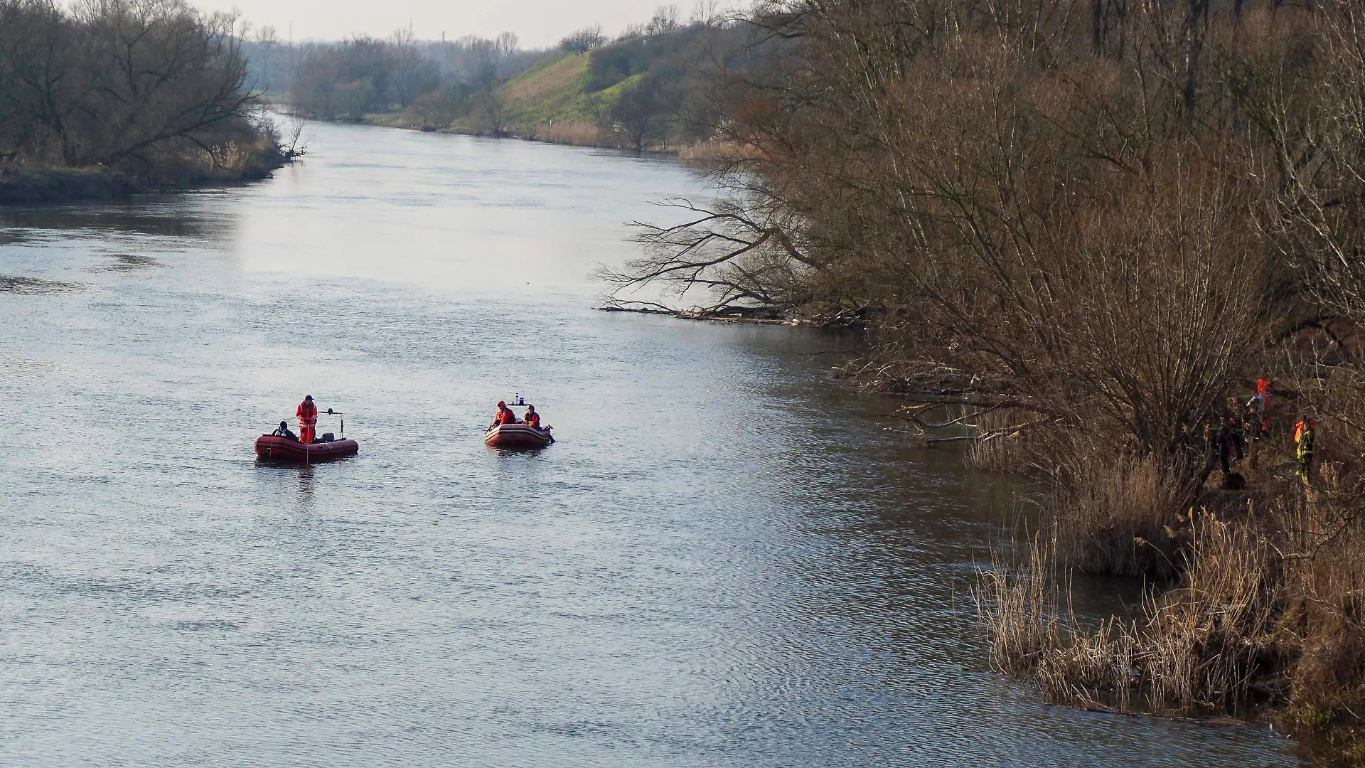 08.03.2024, Sachsen-Anhalt, Halle (Saale): Einsatzkräfte von Feuerwehr und Wasserwacht suchen nach einem versunkenen Fahrzeug in der Saale. Ein Auto ist nahe der Röpziger Brücke in die Saale gerollt und gesunken. Ob sich ein Mensch in dem Wagen befindet, sei bislang unklar, teilte die Feuerwehr mit. Foto: Lucas Libke/EHL Media/dpa +++ dpa-Bildfunk +++