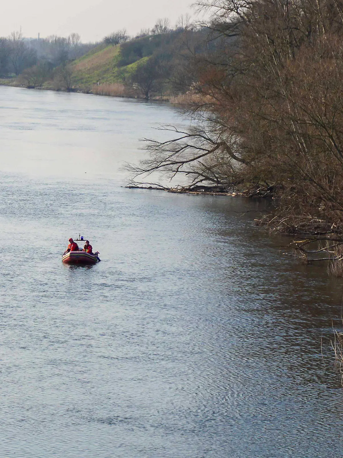 08.03.2024, Sachsen-Anhalt, Halle (Saale): Einsatzkräfte von Feuerwehr und Wasserwacht suchen nach einem versunkenen Fahrzeug in der Saale. Ein Auto ist nahe der Röpziger Brücke in die Saale gerollt und gesunken. Ob sich ein Mensch in dem Wagen befindet, sei bislang unklar, teilte die Feuerwehr mit. Foto: Lucas Libke/EHL Media/dpa +++ dpa-Bildfunk +++