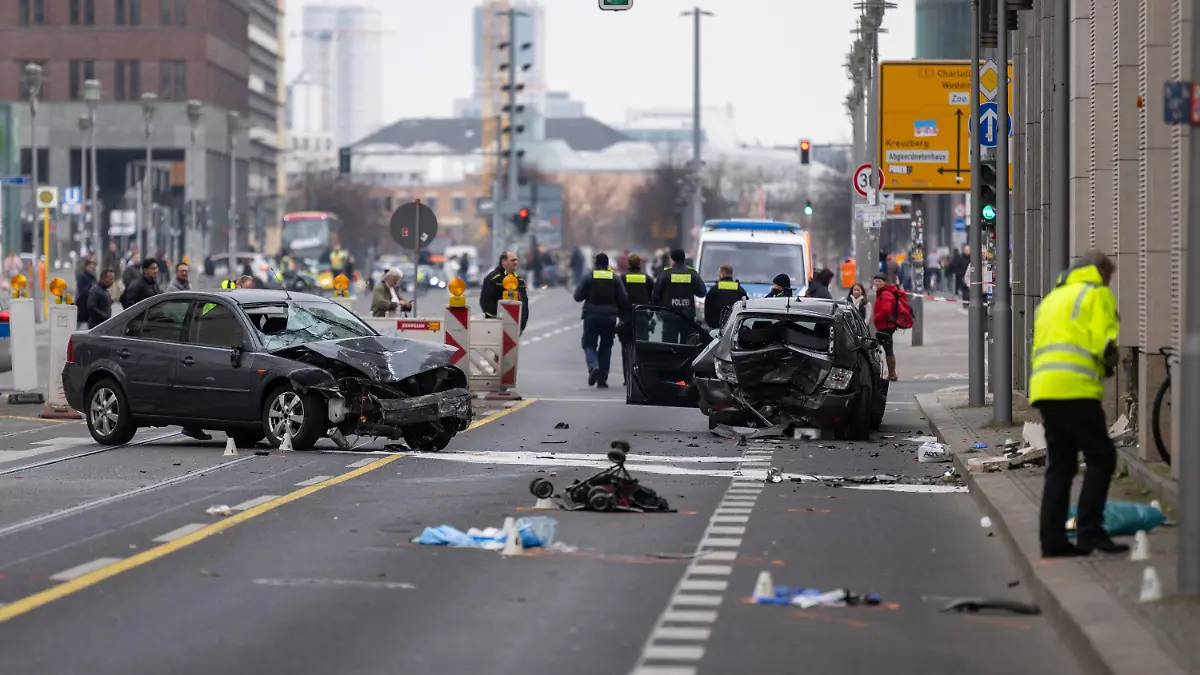 09.03.2024, Berlin: Polizisten stehen an einer Unfallstelle in der Leipziger Straße. Bei dem schweren Unfall in Berlin-Mitte sind vier Menschen, darunter eine Mutter und ihr Kind, schwer verletzt worden. Foto: Christophe Gateau/dpa - ACHTUNG: Ein Kennzeichen wurde aus rechtlichen Gründen gepixelt +++ dpa-Bildfunk +++