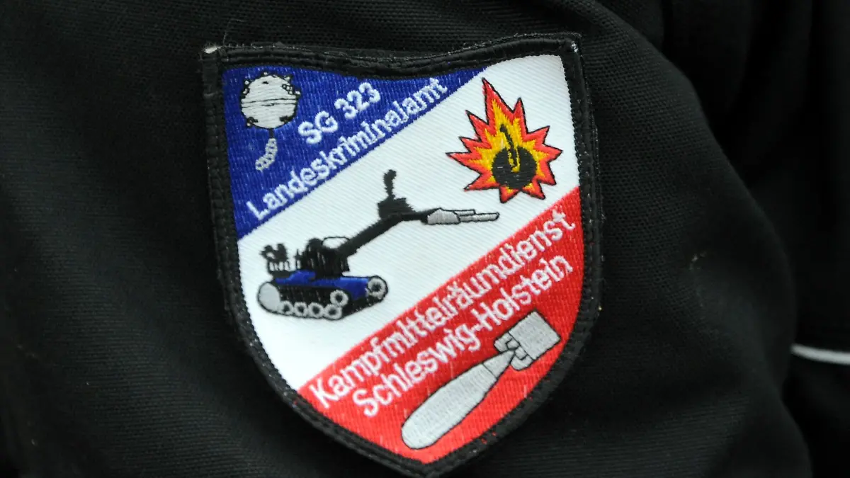 Das Wappen des Kampfmittelräumdienstes des Landeskriminalamtes ist bei einer Bombenentschärfung am Arm eines Sprengmeisters zu sehen.