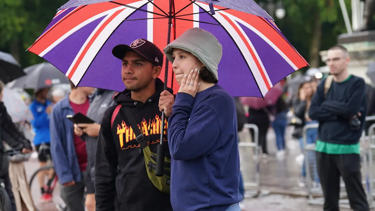08.09.2022, Großbritannien, London: Zwei Personen stehen vor dem Buckingham Palace. Die britische Königin Elizabeth II. ist tot. Sie starb am 08.09.2022 im Alter von 96 Jahren auf ihrem Landsitz Schloss Balmoral in Schottland, wie der Palast mitteilte. Foto: Yui Mok/PA Wire/dpa +++ dpa-Bildfunk +++