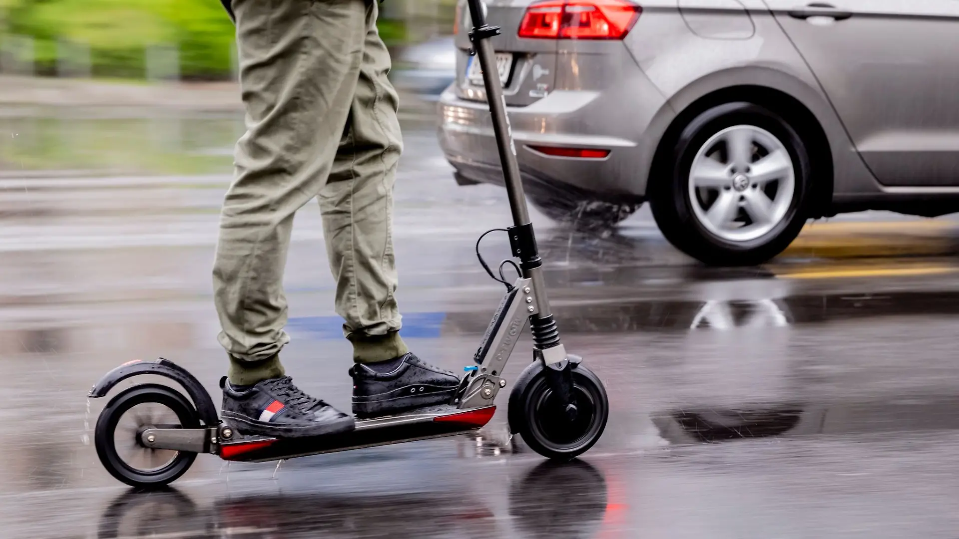 Ein Mann fährt mit einem E-Scooter auf der Straße.