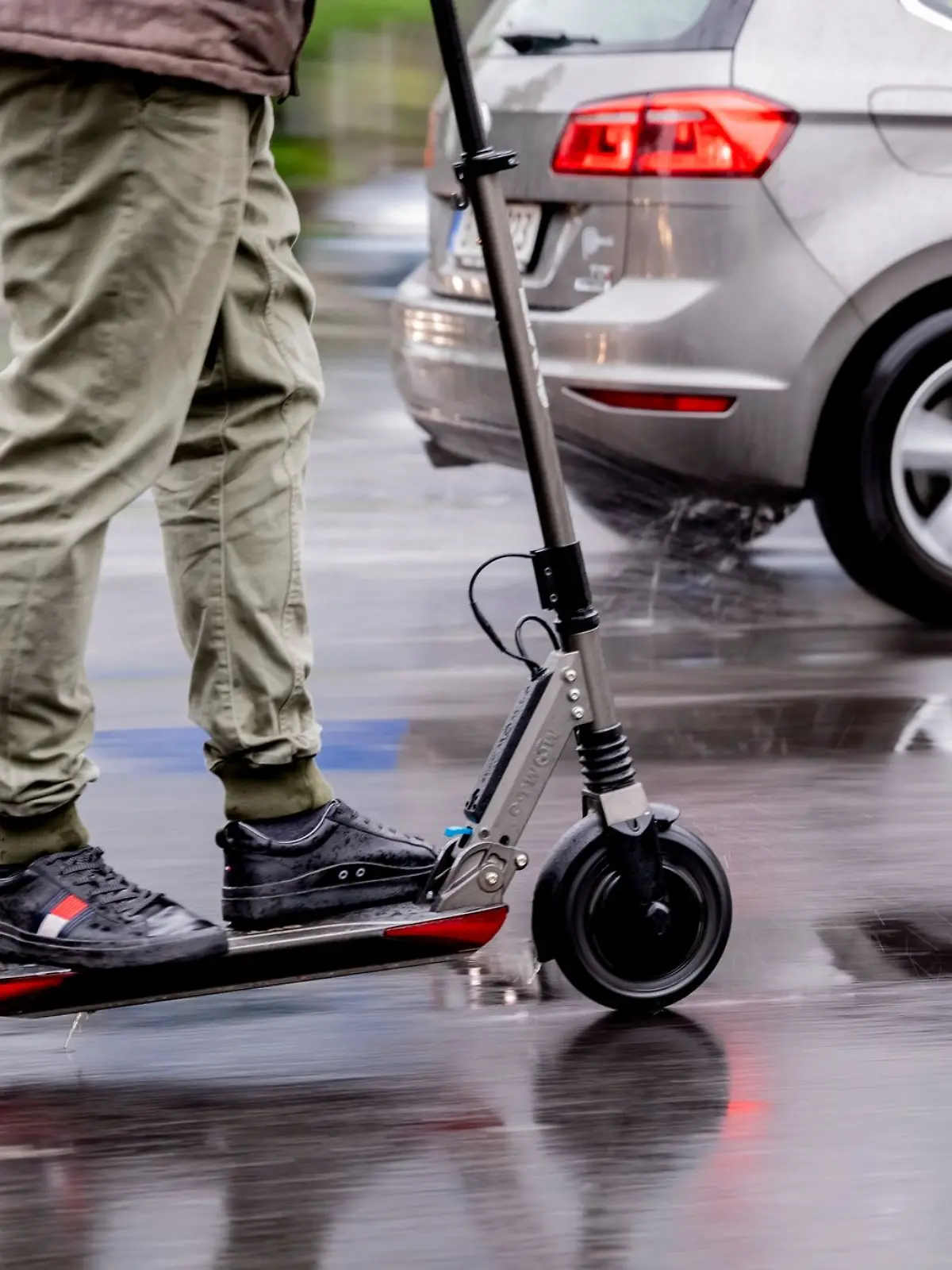 Ein Mann fährt mit einem E-Scooter auf der Straße.