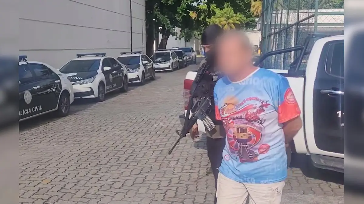 Ein Mann wird in Handschellen von einem Polizisten abgeführt.