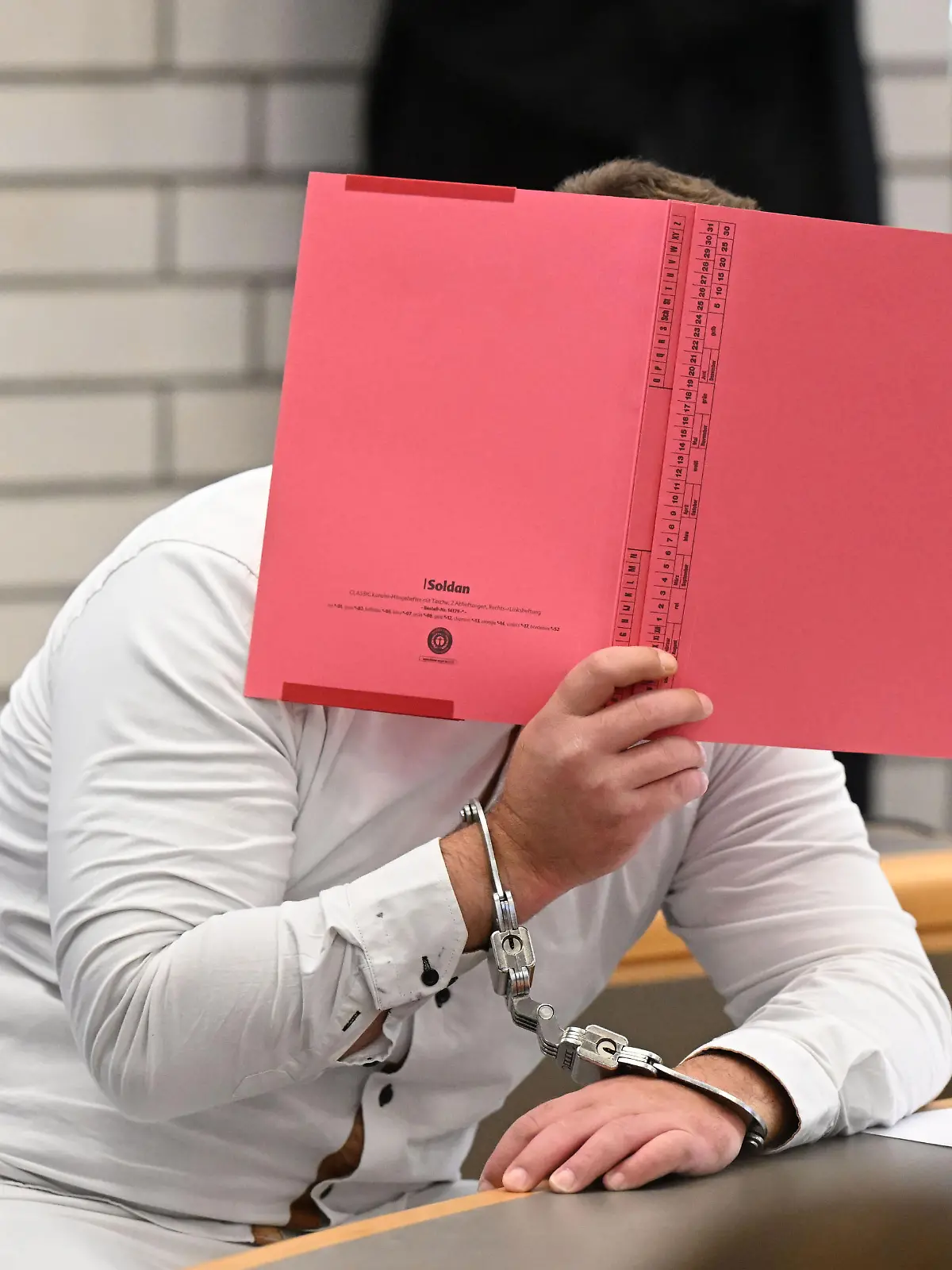 Der Angeklagte im Prozess wegen Mordes an einer Sechsjährigen und Störung der Totenruhe wartet in einem Verhandlungssaal im Landgericht Baden-Baden auf den Prozessbeginn. Der heute 34-jährige soll das Mädchen laut Staatsanwaltschaft mit einem Messer getötet haben, „um sich hierdurch und anschließend mithilfe ihres Leichnams sexuell zu erregen“. Danach habe er versucht, eine Explosion zu verursachen - obwohl vier Verwandte in dem Gebäude schliefen. Er selbst wollte sich laut Staatsanwaltschaft das Leben nehmen.