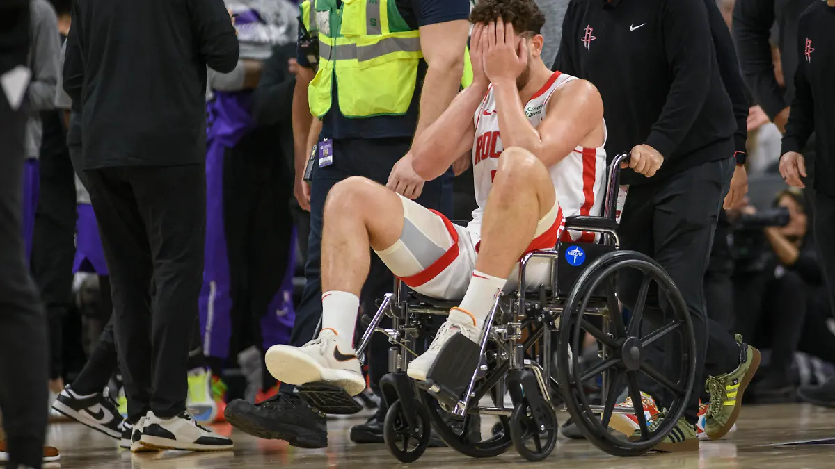 Houston Rockets center Alperen Sengun is wheeled from the arena in a wheel chair during the second half of an NBA basketball game against the Sacramento Kings in Sacramento, Calif., Sunday, March 10, 2024. (AP Photo/Randall Benton)