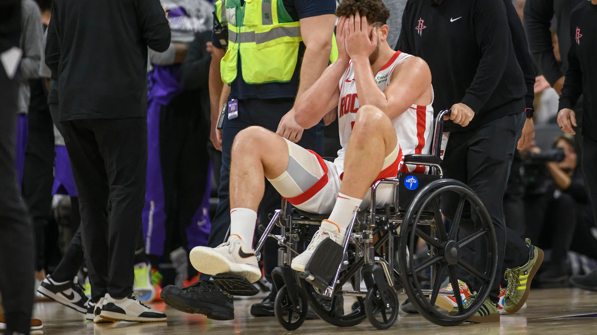 Houston Rockets center Alperen Sengun is wheeled from the arena in a wheel chair during the second half of an NBA basketball game against the Sacramento Kings in Sacramento, Calif., Sunday, March 10, 2024. (AP Photo/Randall Benton)