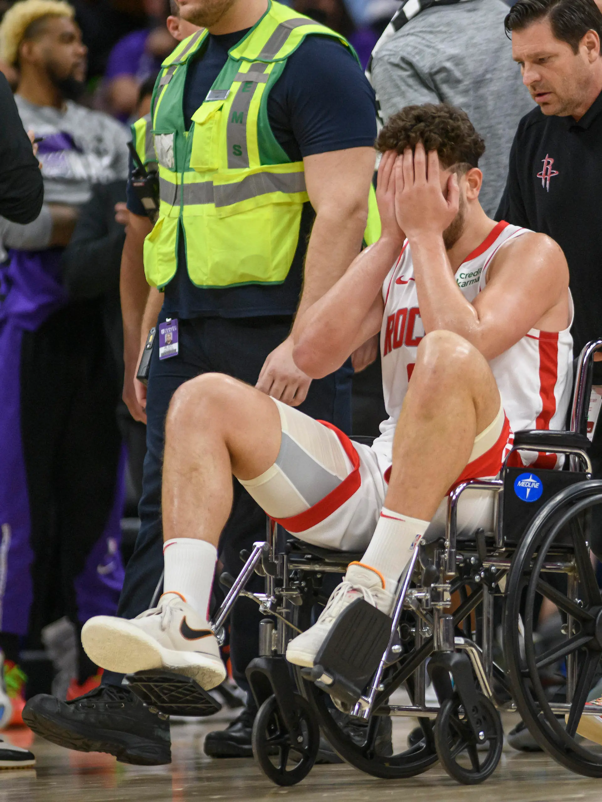 Houston Rockets center Alperen Sengun is wheeled from the arena in a wheel chair during the second half of an NBA basketball game against the Sacramento Kings in Sacramento, Calif., Sunday, March 10, 2024. (AP Photo/Randall Benton)