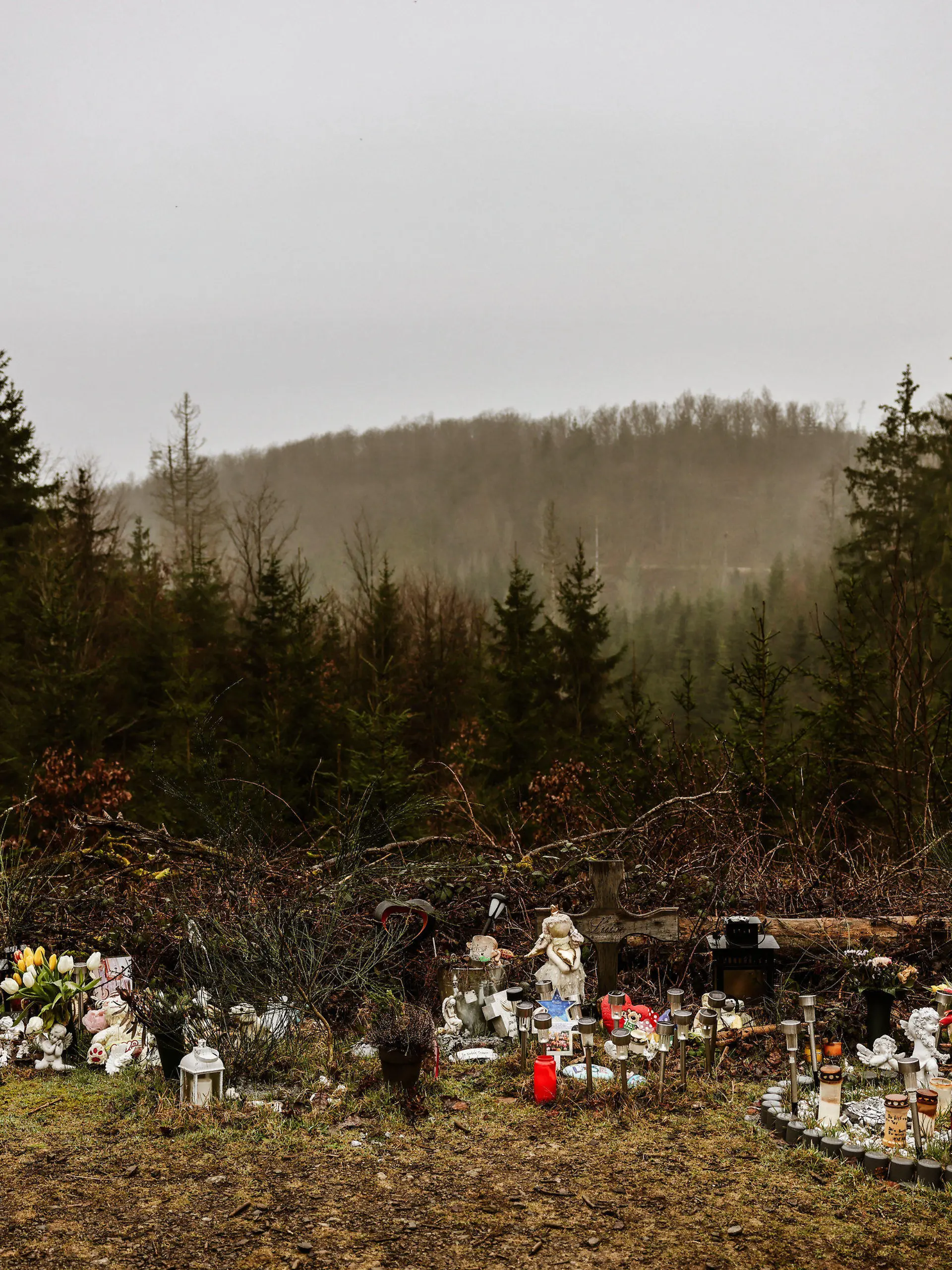 05.03.2024, Nordrhein-Westfalen, Freudenberg: Kerzen, Blumen und Figuren liegen am Fundort an der Landesgrenze zwischen Rheinland-Pfalz und Nordrhein-Westfalen. Die zwölf Jahre alte Schülerin Luise war im März 2023 erstochen worden. Zwei strafunmündige Mädchen hatten die Tat gestanden. (Zu dpa: ·Ein Jahr nach gewaltsamen Tod von Luise - das Entsetzten bleibt·) Foto: Oliver Berg/dpa +++ dpa-Bildfunk +++