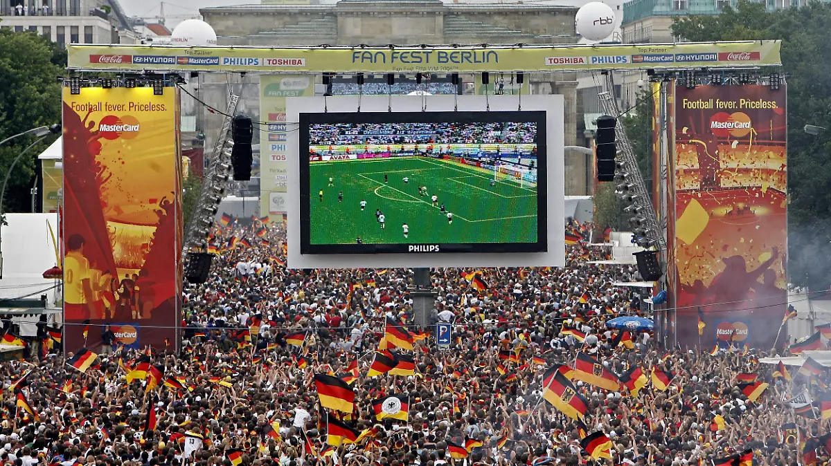 ARCHIV - 30.06.2006, NA, Berlin: Tausende Zuschauer verfolgen auf der Fanmeile am Brandenburger Tor in Berlin das WM-Fußballspiel zwischen Deutschland und Argentinien. (zu dpa: «Ministerin: Public Viewing bei EM «bis in die späteren Abendstunden»») Foto: Marcel Mettelsiefen/dpa +++ dpa-Bildfunk +++