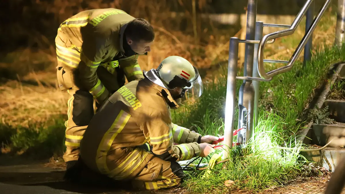 12.03.2024, Niedersachsen, Etelsen: Feuerwehrleute untersuchen eine Laterne und ein Geländer am Bahnhof Etelsen und messen die elektrische Spannung. Durch einen Stromschlag ist ein 14-Jähriger am Dienstagabend an dem Bahnhof im Landkreis Verden schwer verletzt worden.(zu dpa: «14-Jähriger durch Stromschlag am Bahnhof im Kreis Verden verletzt») Foto: Christian Butt/NWM-TV/dpa +++ dpa-Bildfunk +++