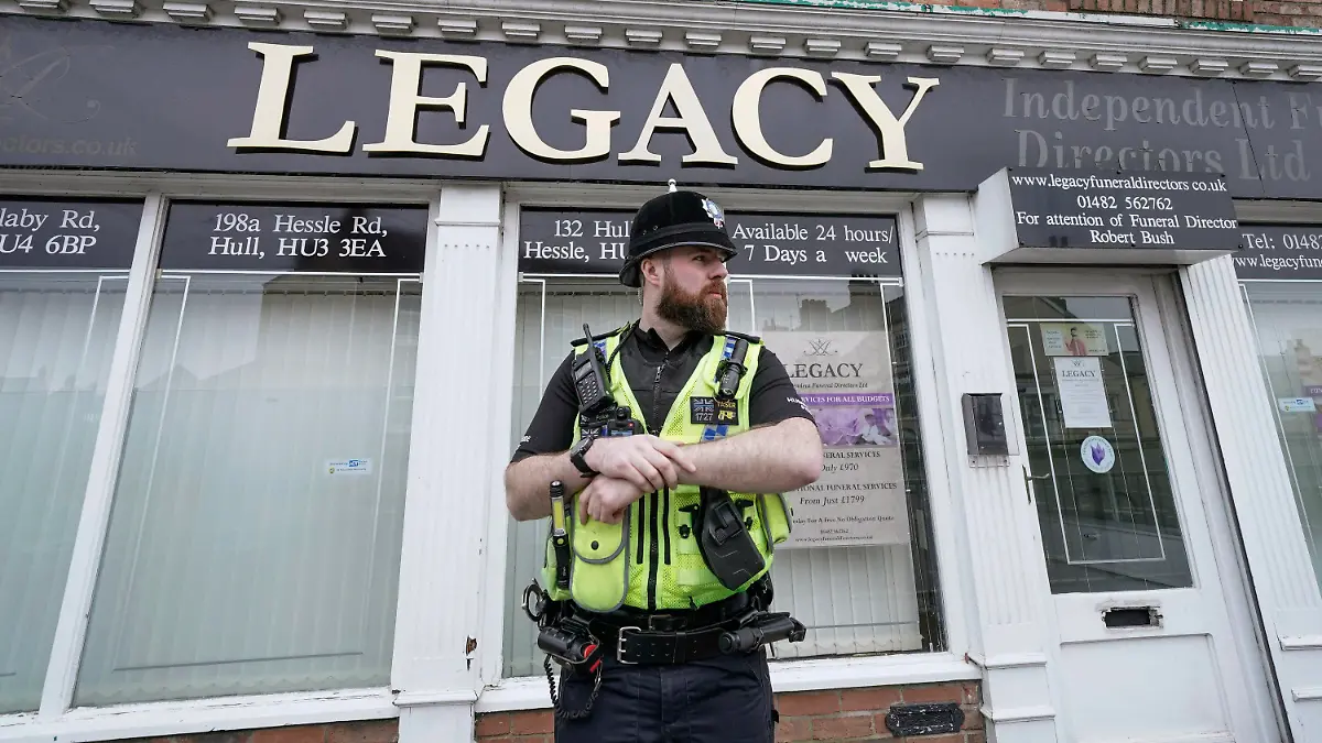 Police stand guard outside the Beckside branch of Legacy Independent Funeral Directors, in Hull, England, Saturday, March 9, 2024. Police in northern England say they have removed 34 bodies from a funeral home and arrested a man and woman on suspicion of fraud and preventing lawful burials. The arrests Sunday follow several days of investigation at Legacy Funeral Directors in Hull and two related funeral homes. (Danny Lawson/PA via AP)