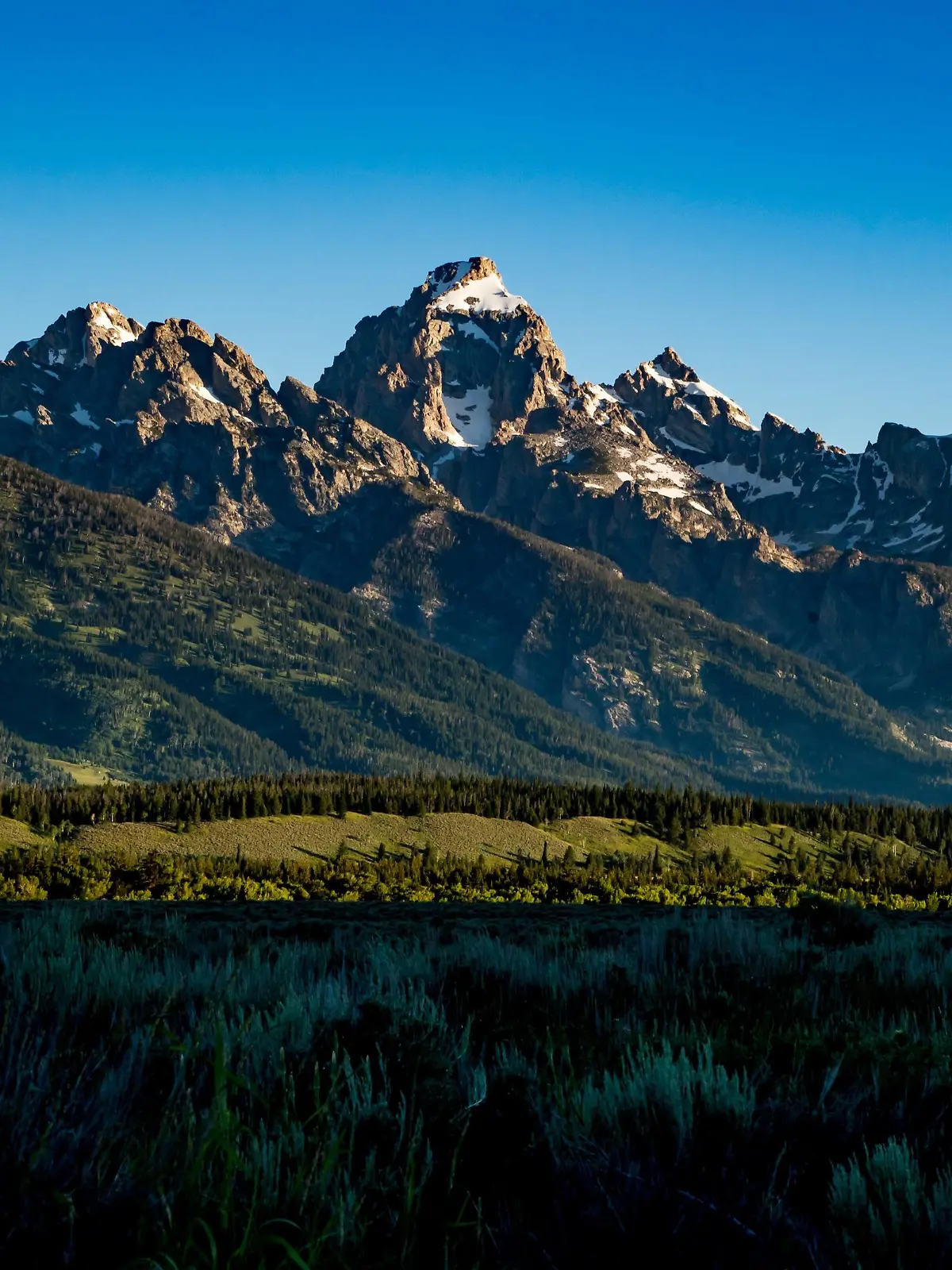 The Teton Range, a mountain range of the Rocky Mountains, is seen as the sun rises in Moose, Wyoming, United States at the Teton Point Turnout on July 13, 2018. It is south of Yellowstone National Park and most of the east side of the range is within Grand Teton National Park. (Photo by Patrick Gorski/NurPhoto) | Keine Weitergabe an Wiederverkäufer.