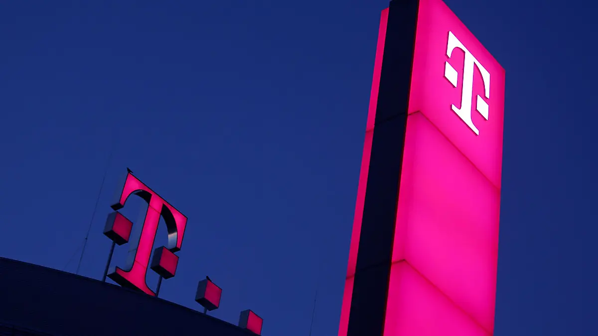 Das Logo der Deutschen Telekom leuchtet auf dem Dach der Unternehmenszentrale.